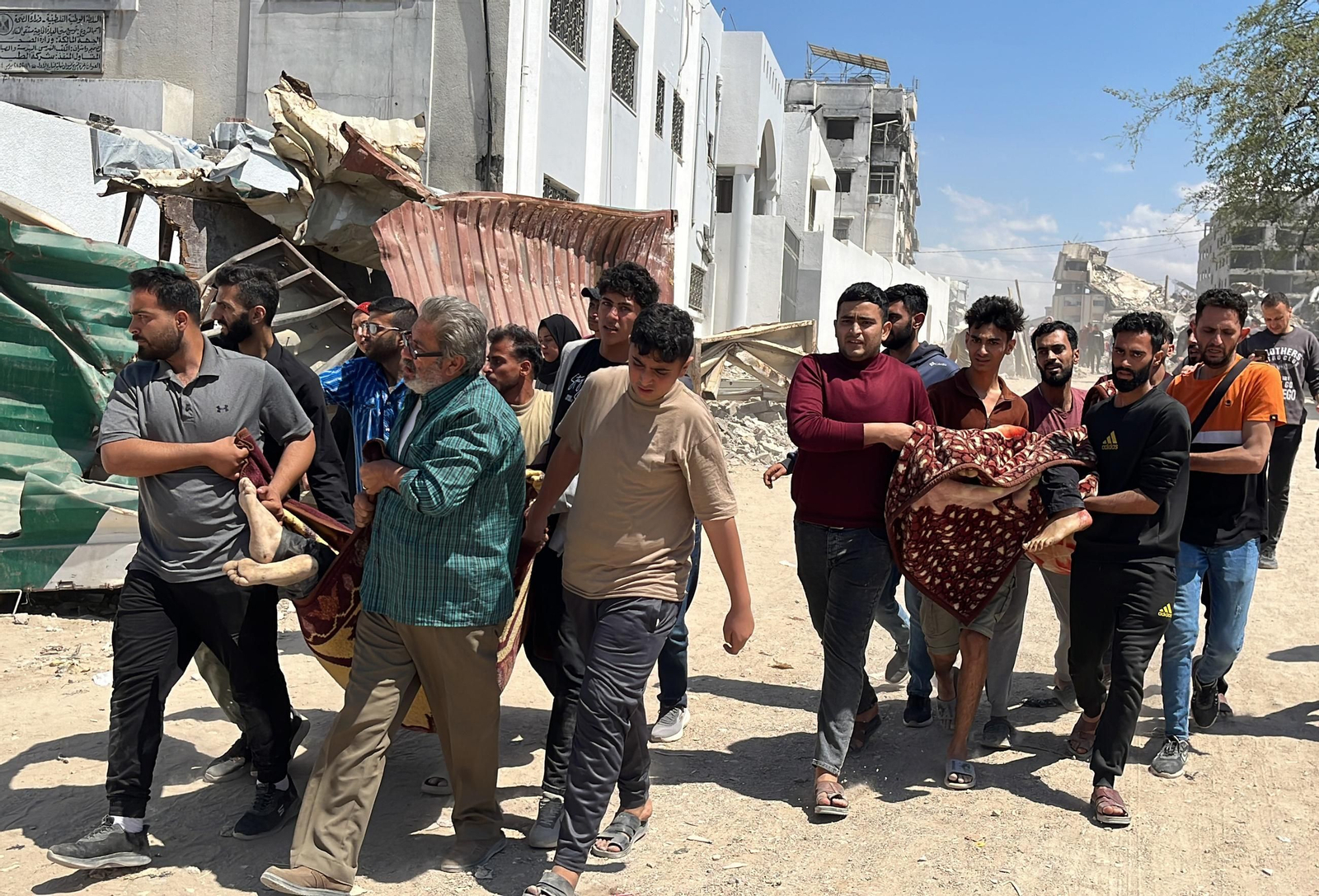 Palestinos en Gaza con los cuerpos de víctimas de la guerra