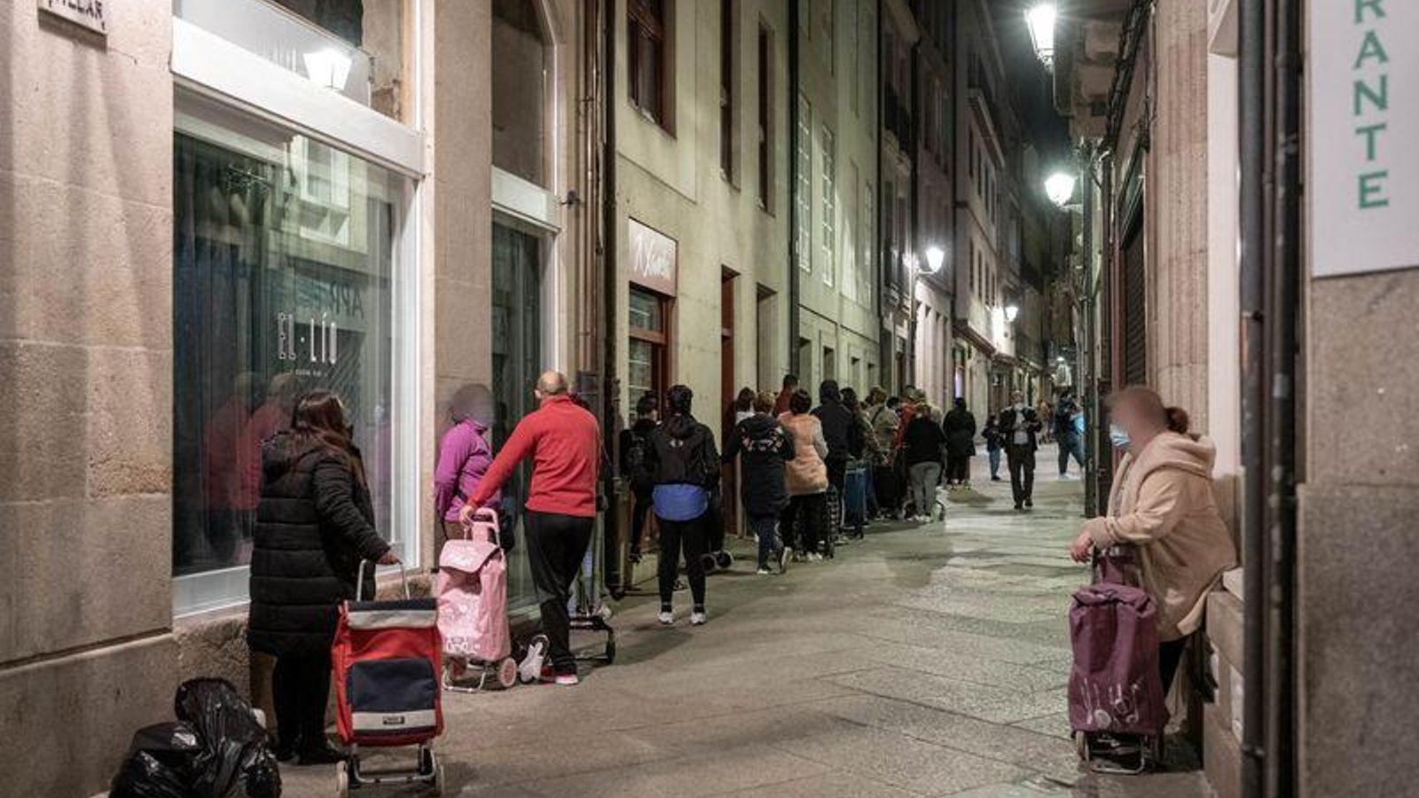  OURENSE (RÚA IRMÁNS VILLAR). 04/03/2021. OURENSE. Un gran grupo de gente hace cola con sus carros para poder llevar comida donada por la parroquia de Santa Eufemia del Centro. FOTO: ÓSCAR PINAL 