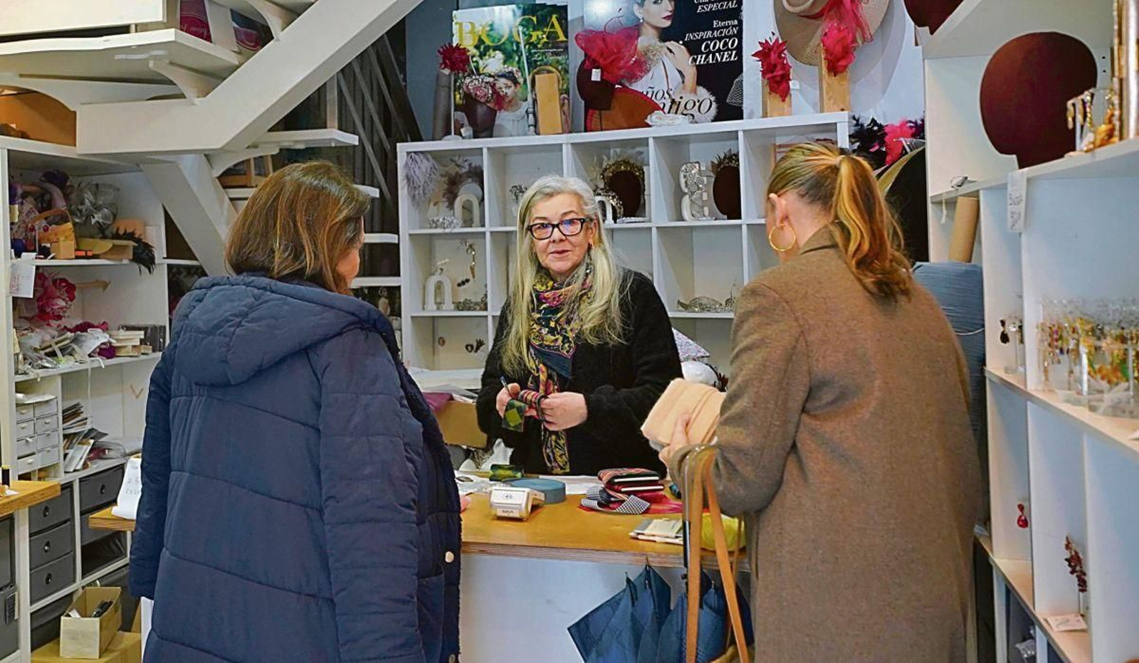Ana Casal tras el mostrador atendiendo a unas clientas en su mercería.