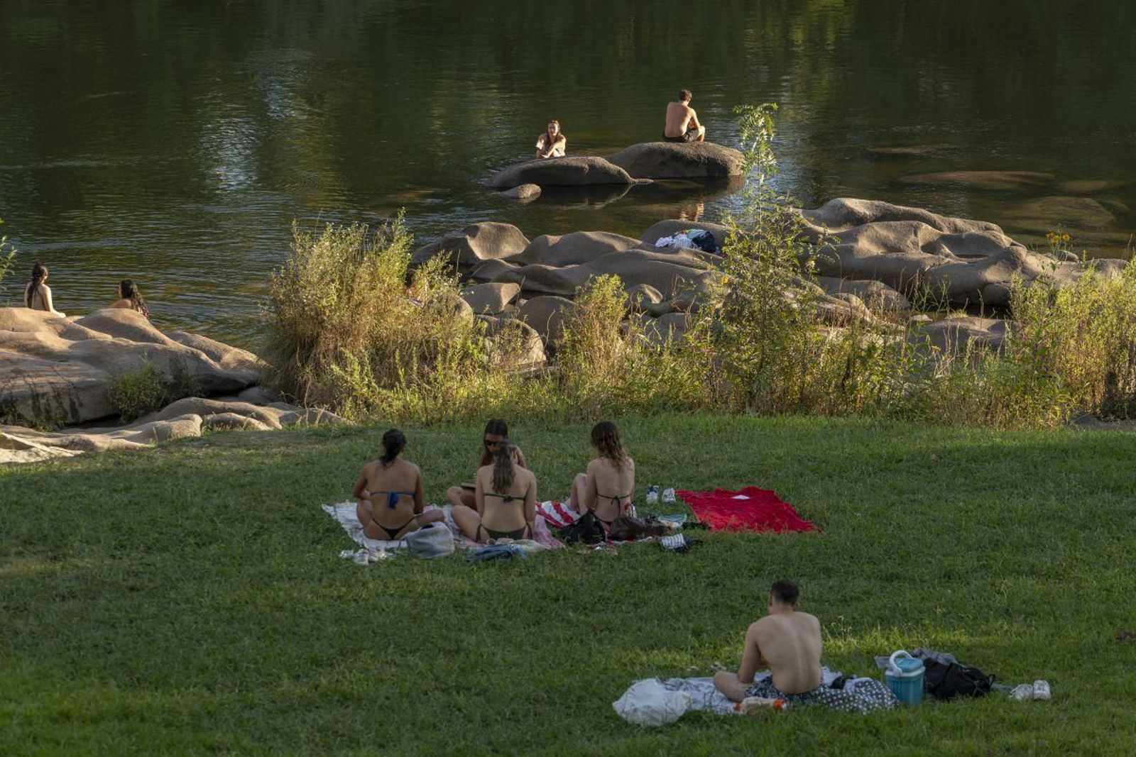 Un grupo de bañistas se refresca en el Miño.