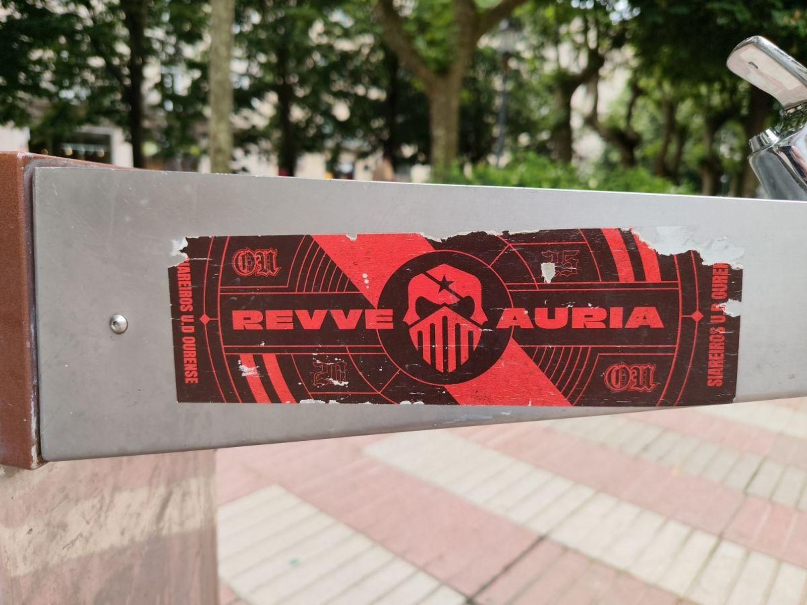 Pegatina de Revve Auria nunha fonte do parque de San Lázaro.