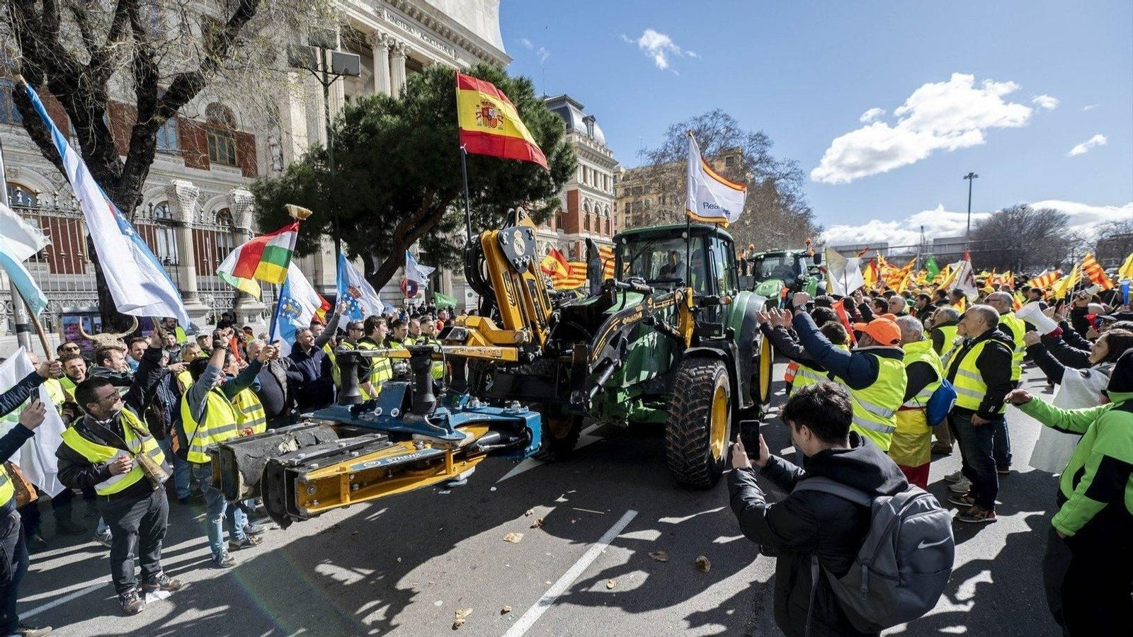 Un tractor llega a la concentración de agricultores en el Ministerio de Agricultura, rodeado por banderas de España, Galicia y otras CCAA (foto: E.P.)