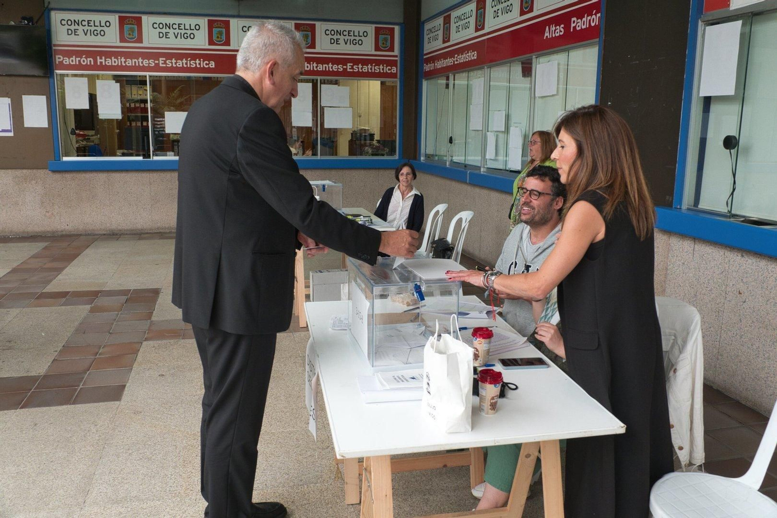 Un hombre introduce su voto en una urna en el Concello de Vigo.