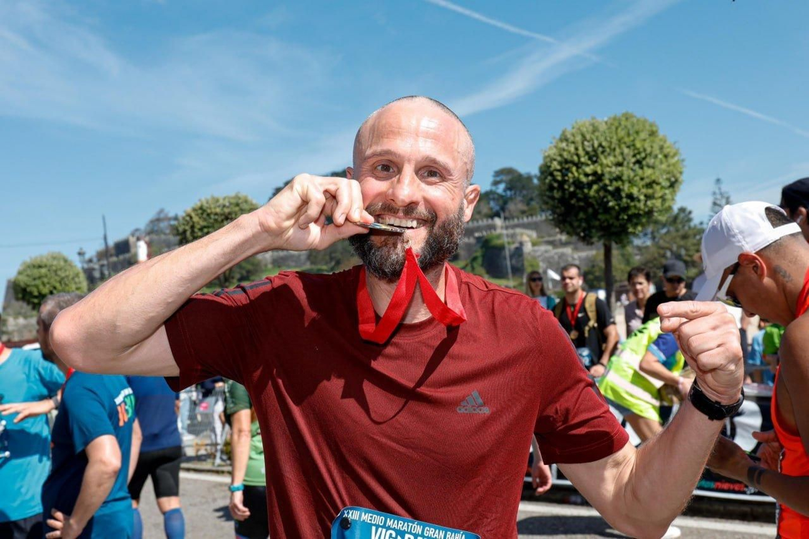 Mordiendo la medalla al finalizar la carrera.
