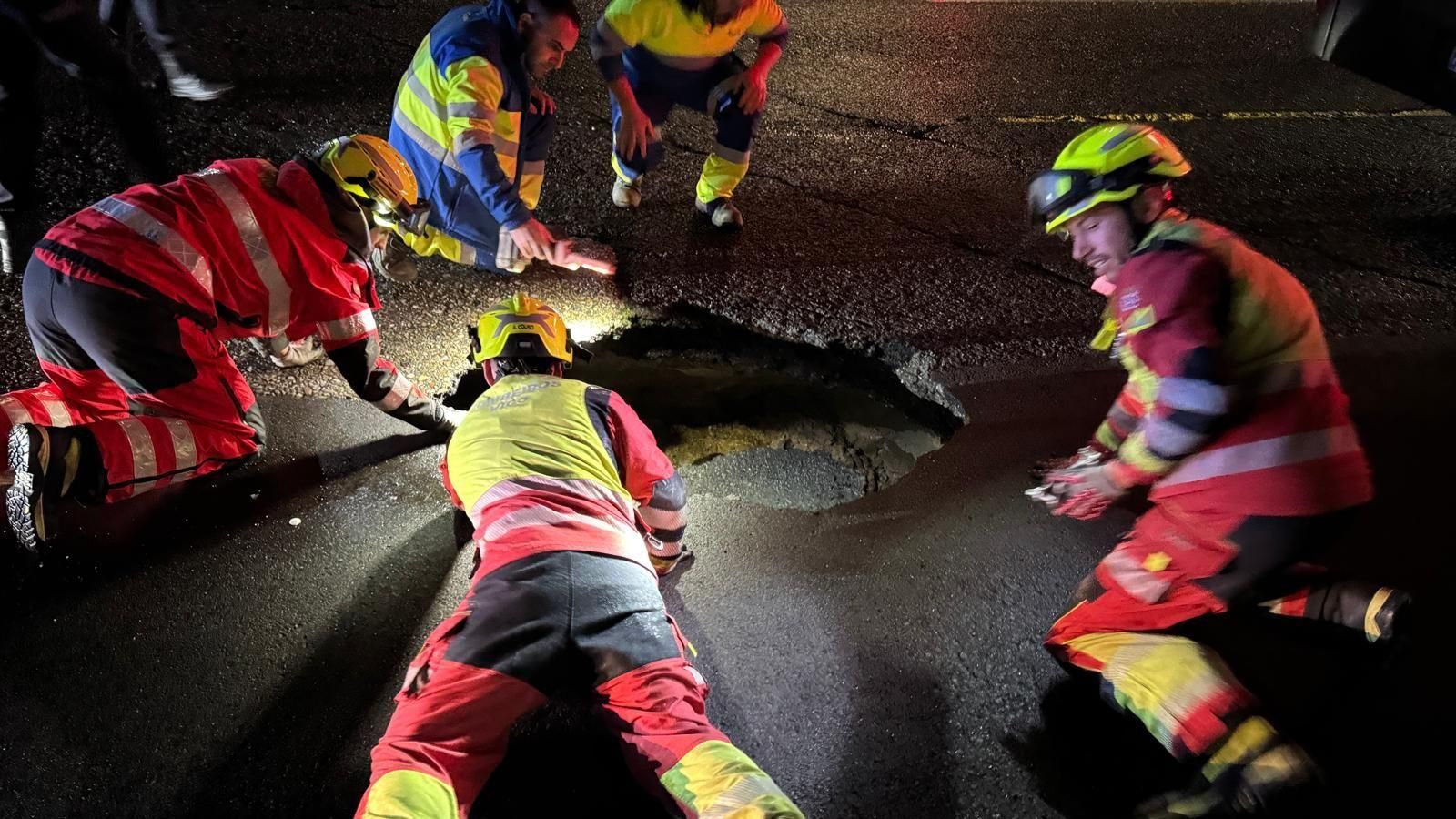 Bomberos inspeccionando el agujero, de gran tamaño.