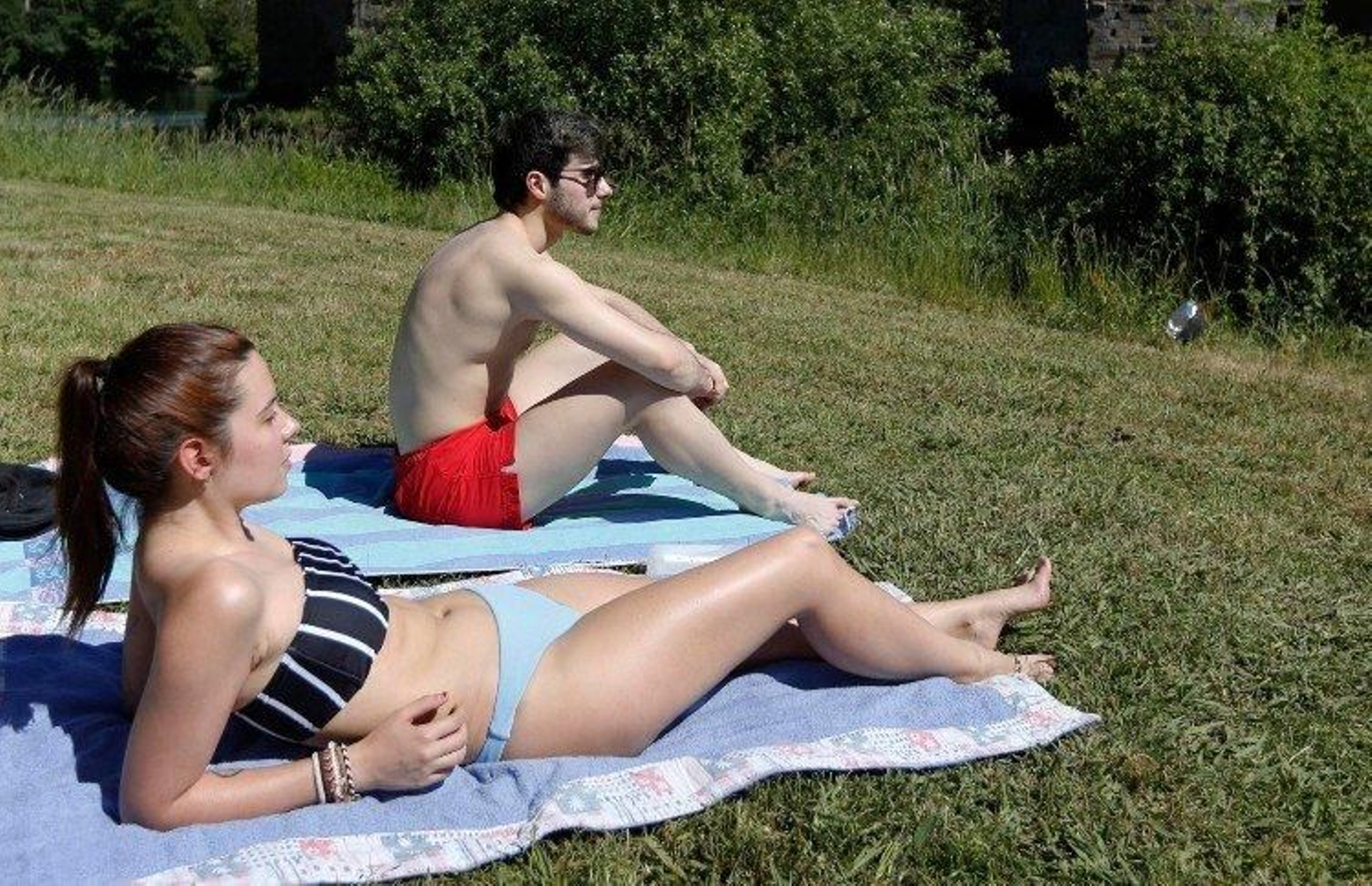 Dos personas toman el sol en la ribera del Miño, el pasado día 30 (XESÚS FARIÑAS).