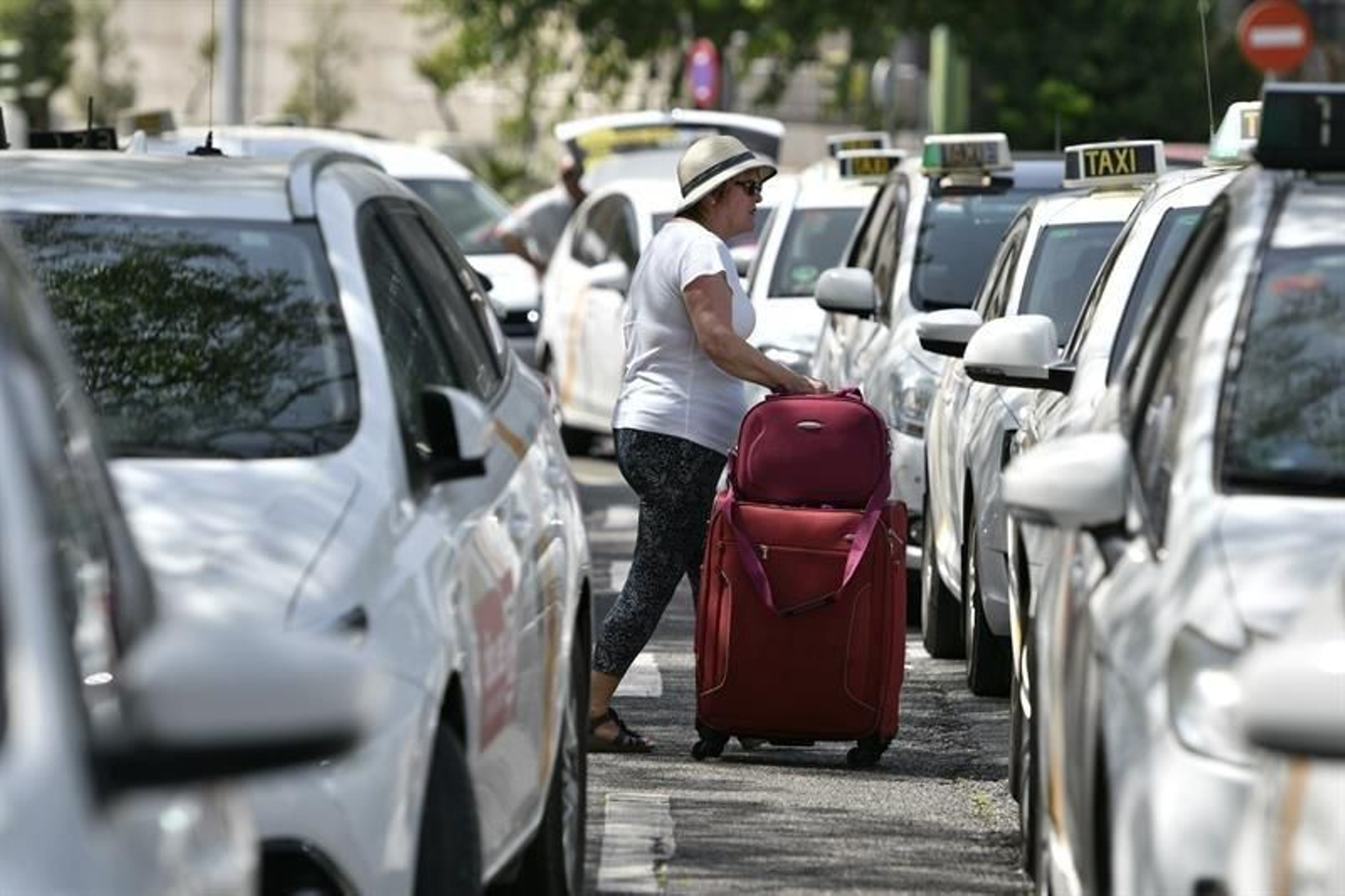 Una mujer busca un taxi disponible.