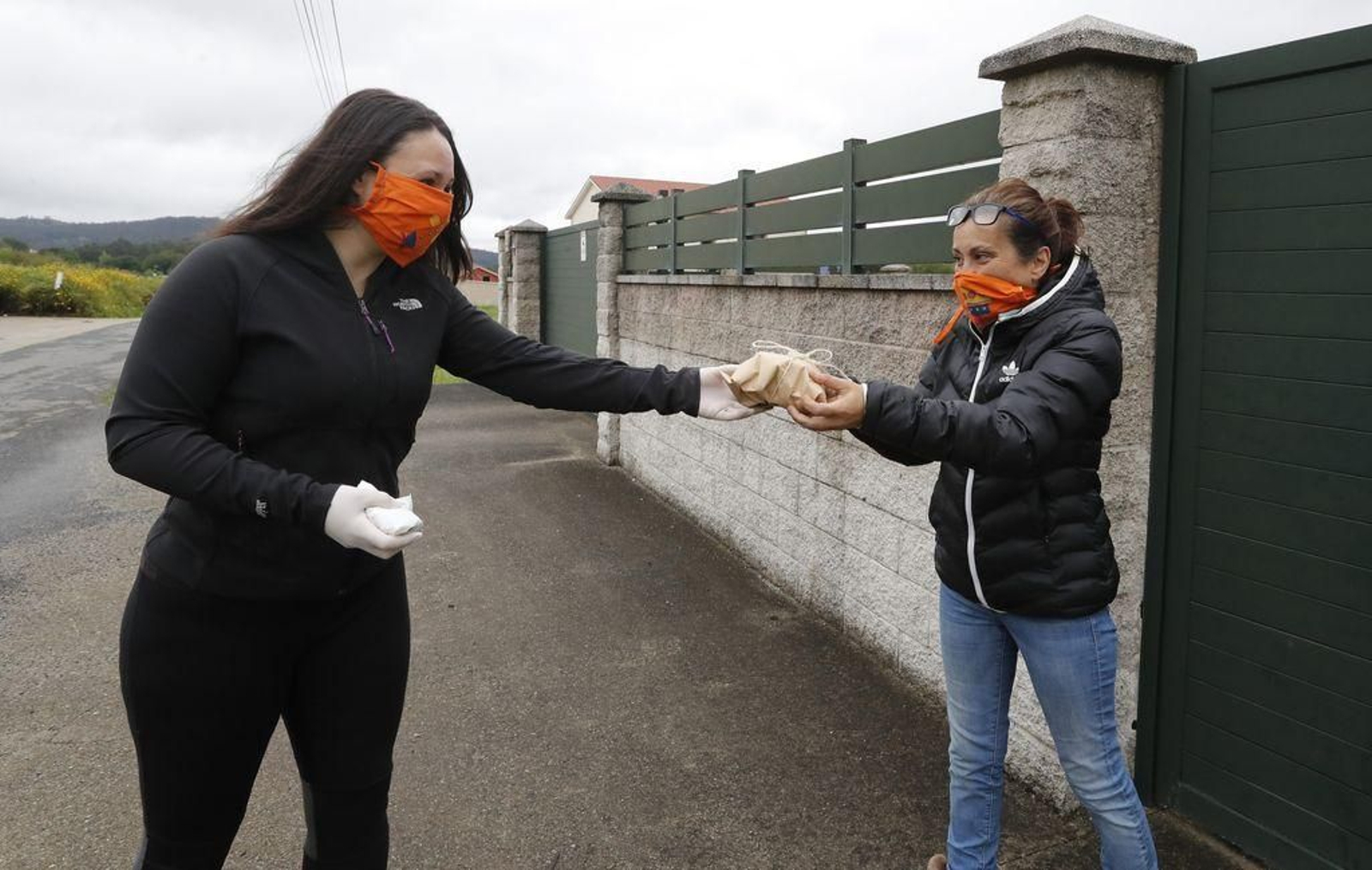 Adelina entrega un pastel de pascua a su vecina Geni, en la aldea de Guisande.