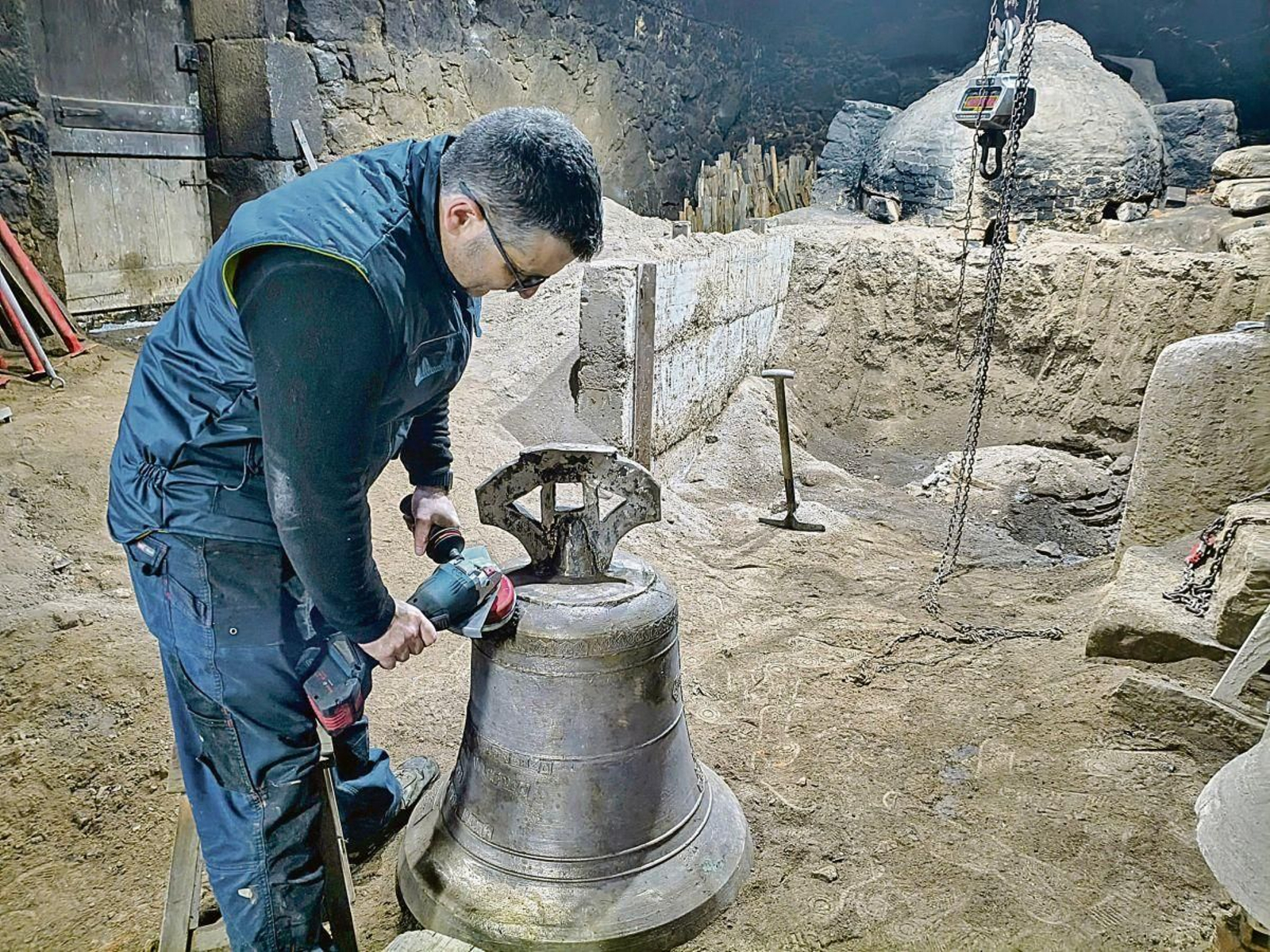 José Enrique López Ocampo en la fundición de Arcos da Condesa (Caldas de Reis) con una campana en restauración (izquierda) y, a la derecha, el artesano con el molde de barro.