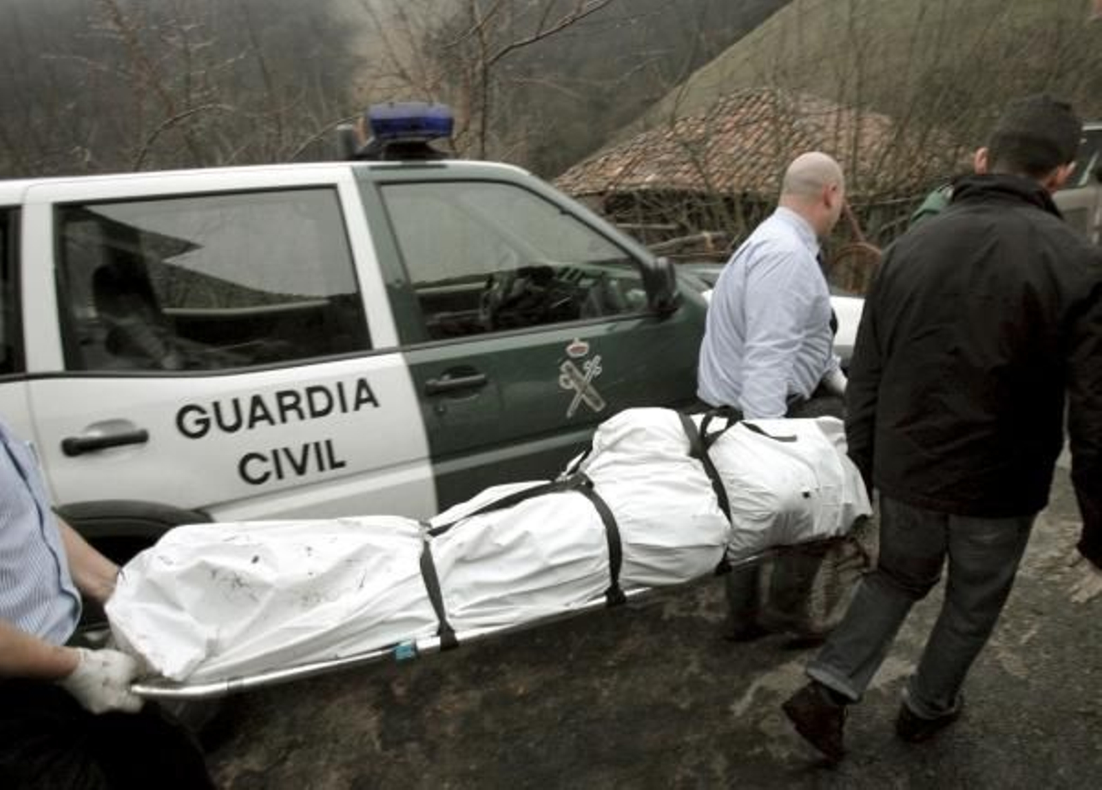Momento del traslado de uno de los cadáveres. (Foto: EFE)