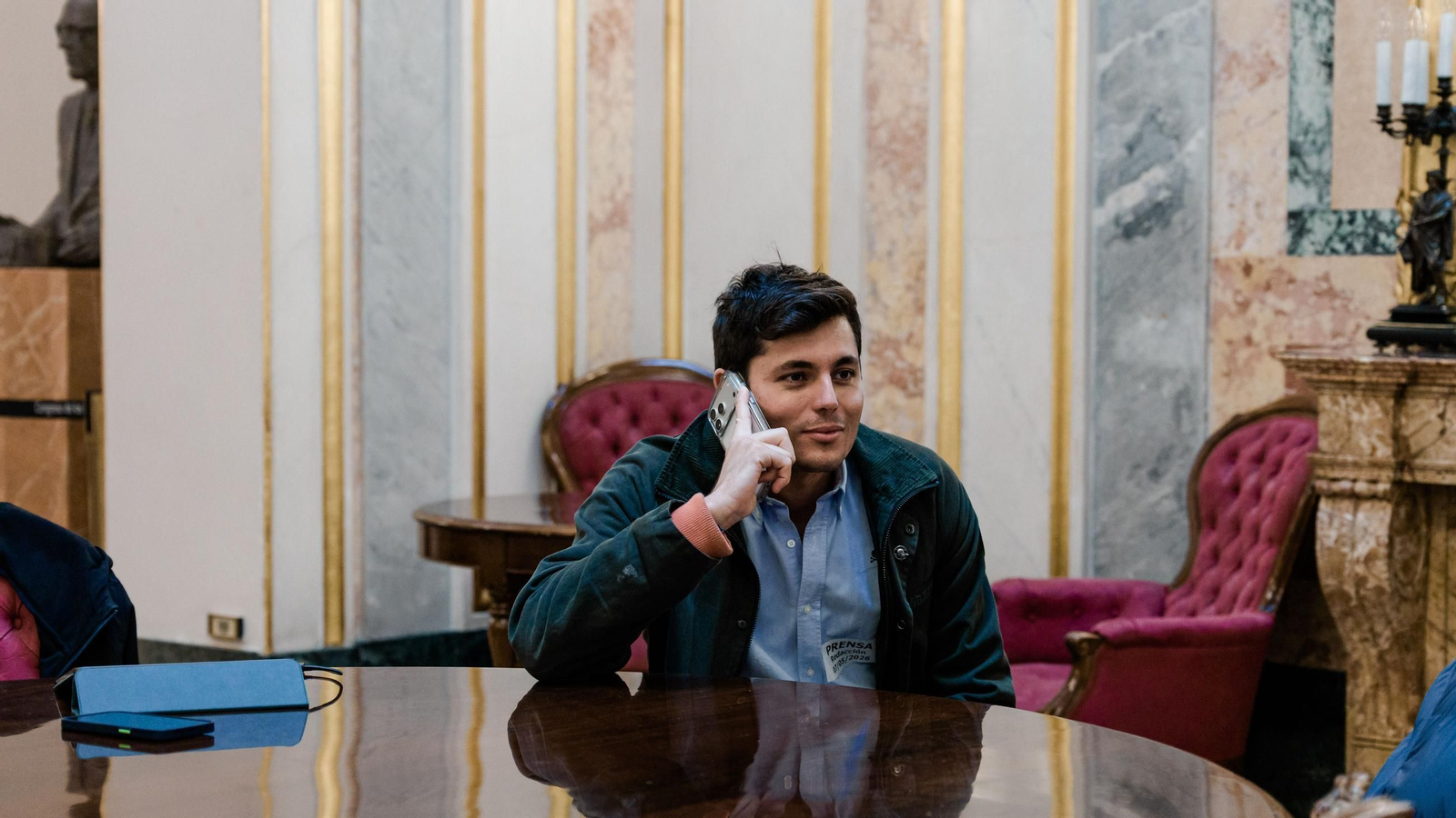 El periodista Vito Quiles habla por teléfono durante una sesión plenaria en el Congreso.