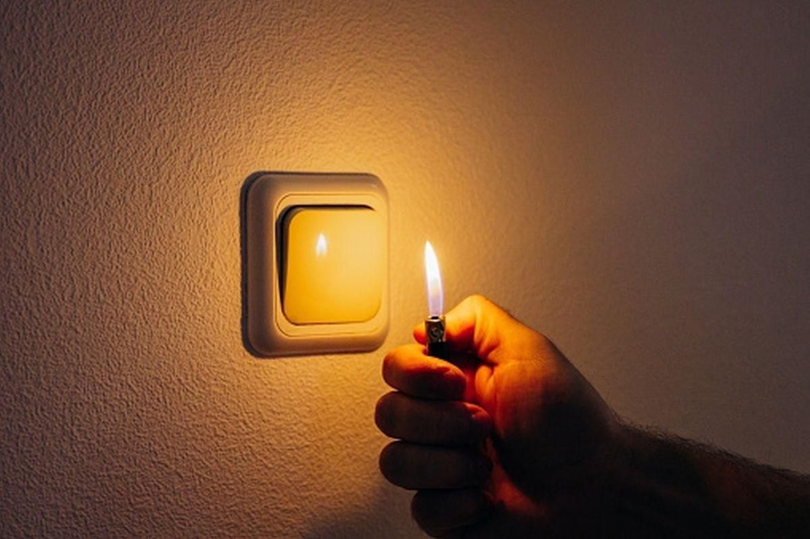 Una casa a oscuras alumbrada por un mechero.