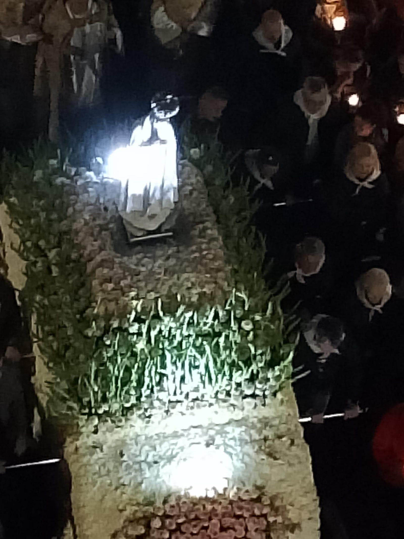 Detalle de la figura de la Virgen de Fátima, profusamente engalanada con flores para su noche más especial en la ciudad