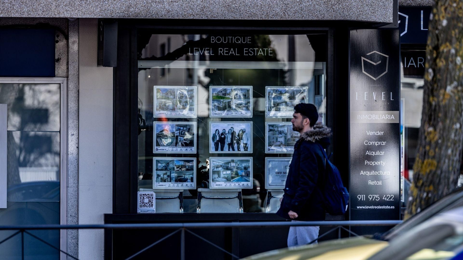 Un joven pasa por delante de una inmobiliaria.