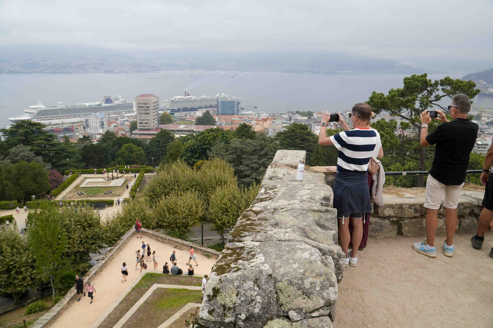 Cruceristas en O Castro, observando la ciudad y los dos buques en la Estación Marítima