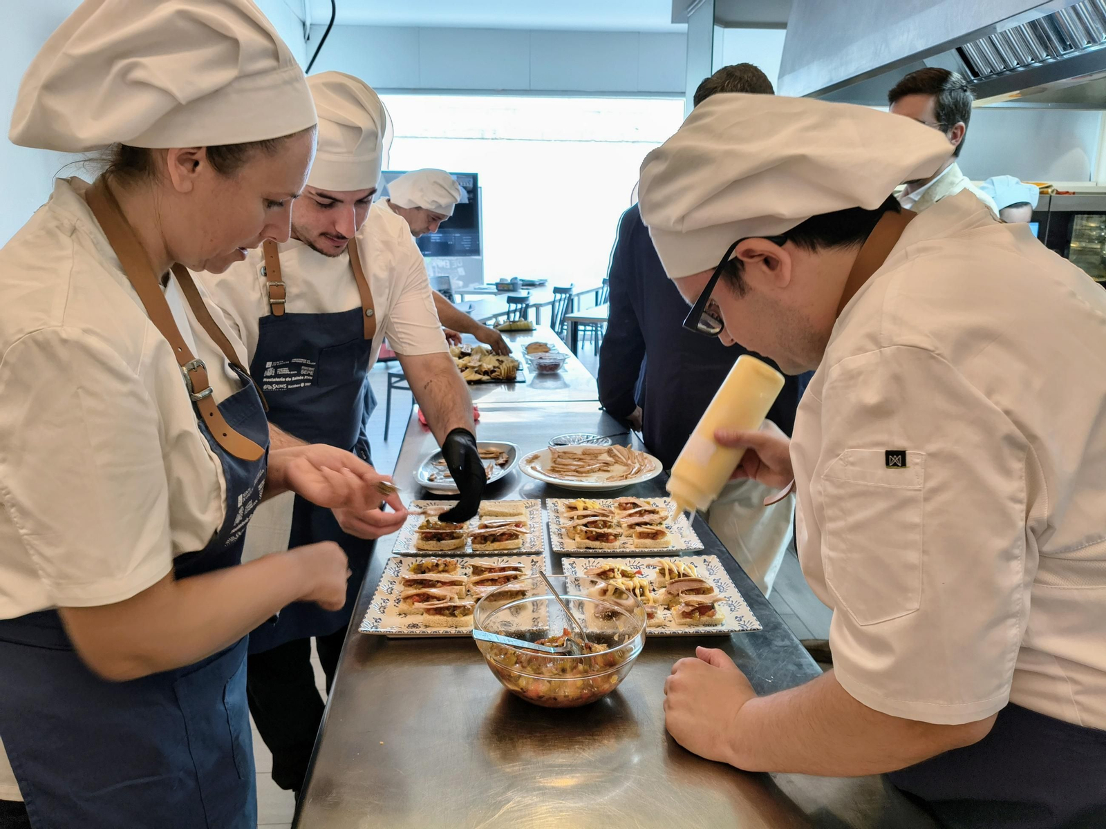 Alumnos del obradoiro dual de la Mancomunidad preparando platos.