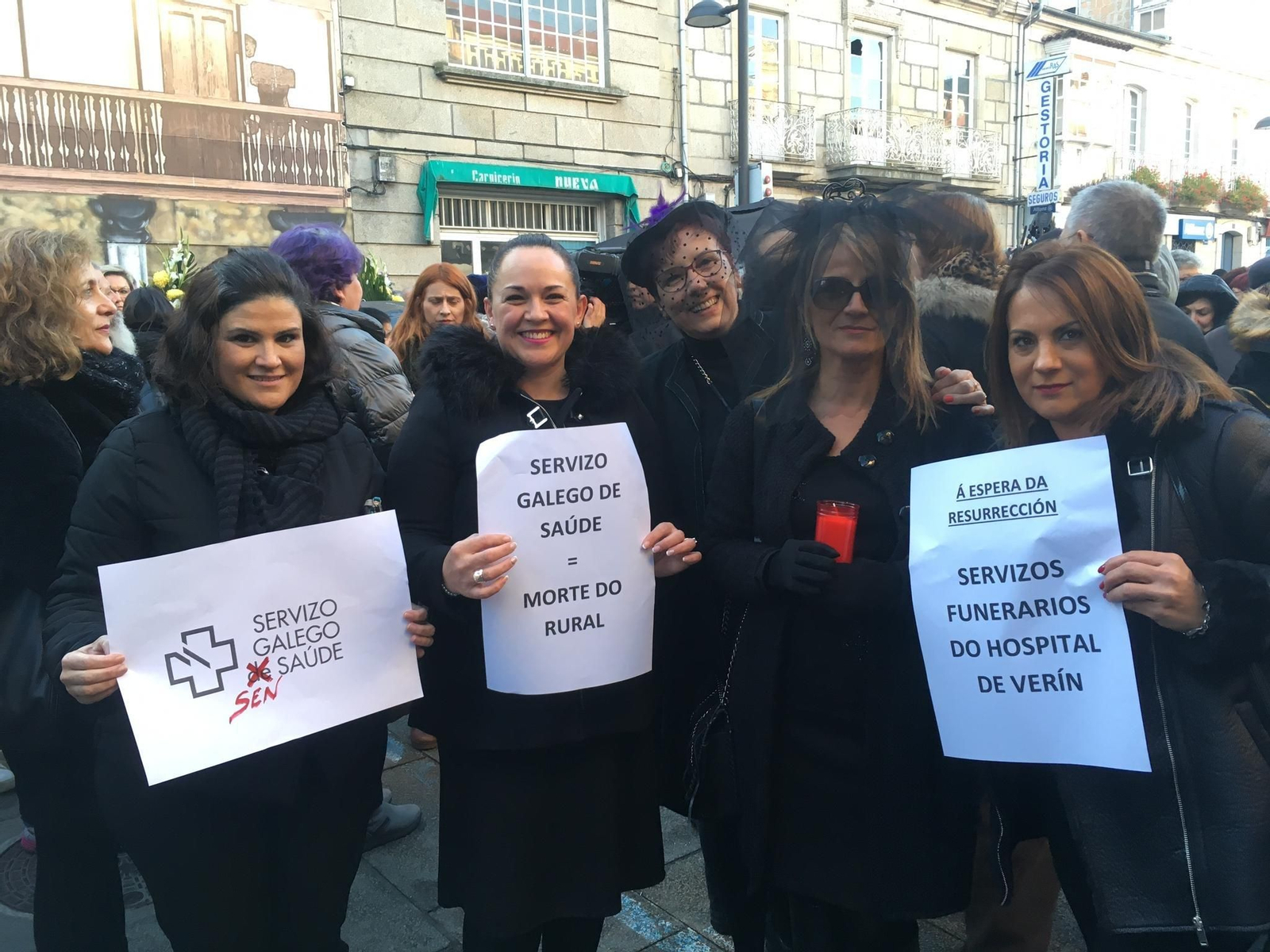 Varias plañideras con pancartas durante la manifestación. // X. Fariñas