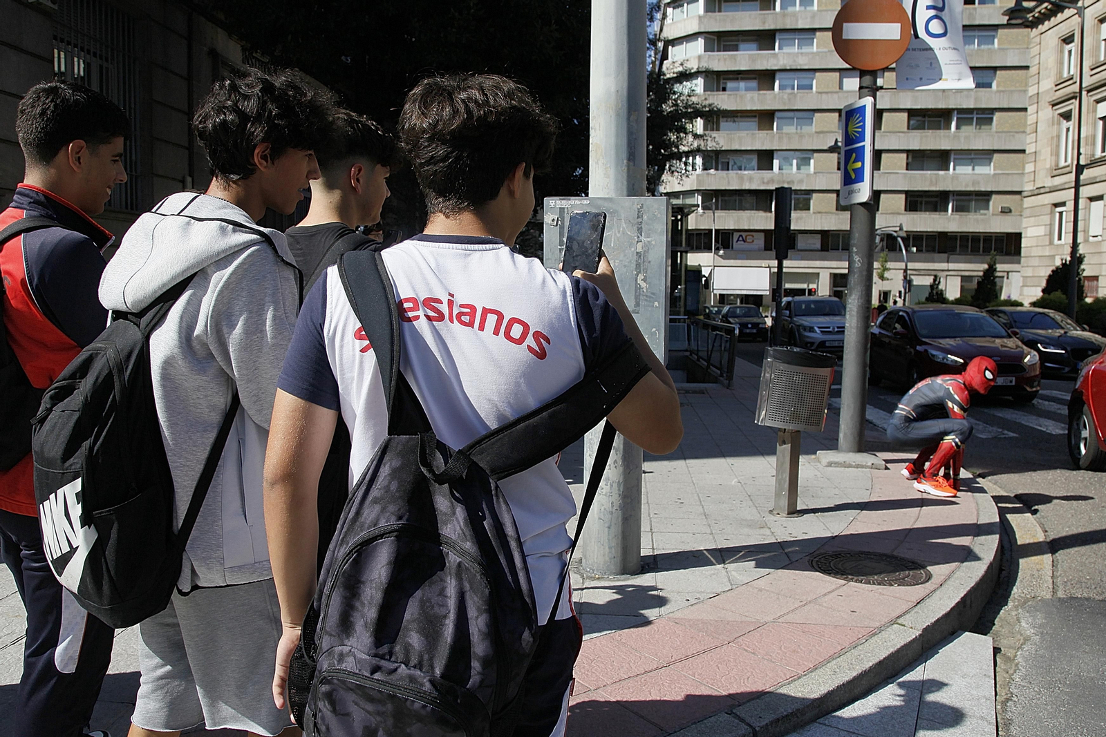 Un grupo de jóvenes, sorprendidos por el súper héroe