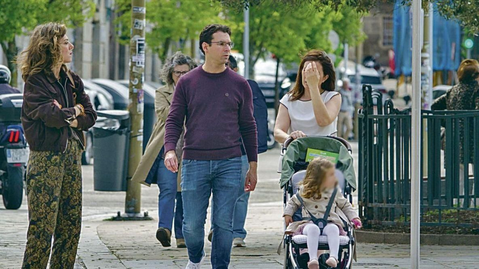 Una pareja pasea a su hija en un carrito en Vigo.