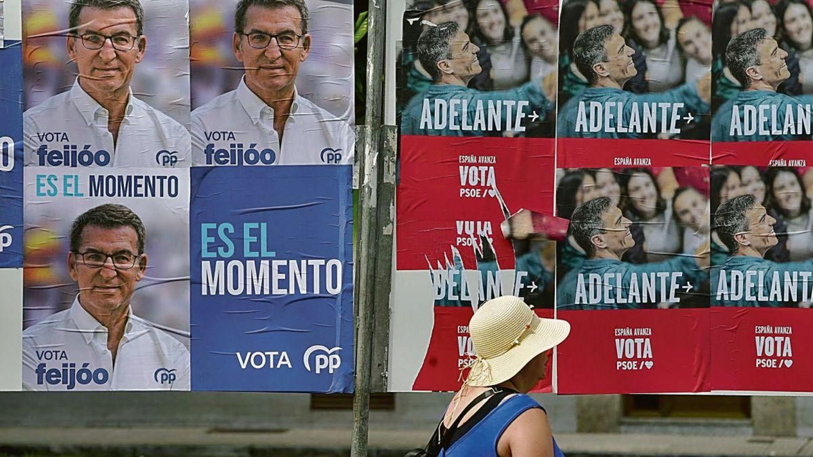 Carteles electorales de PP y PSOE compartiendo valla en Gijón.