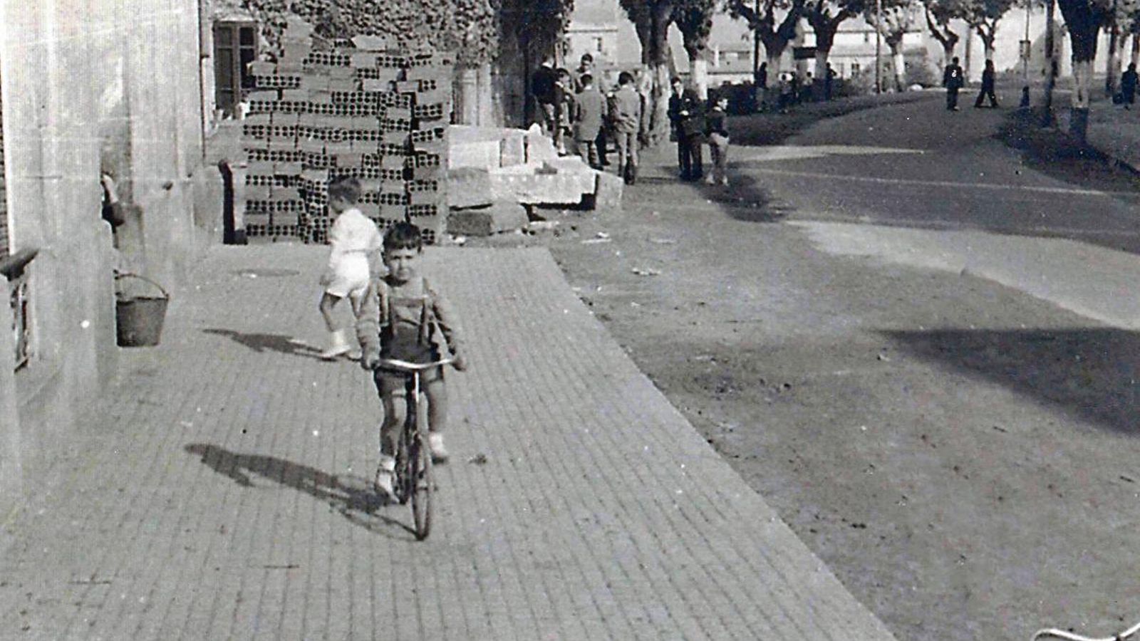 Se aprecia perfectamente cómo era la estética de la calle en aquellos años 50. Grandes árboles daban sombra a los paseantes y el asfalto aún no había invadido las calles.