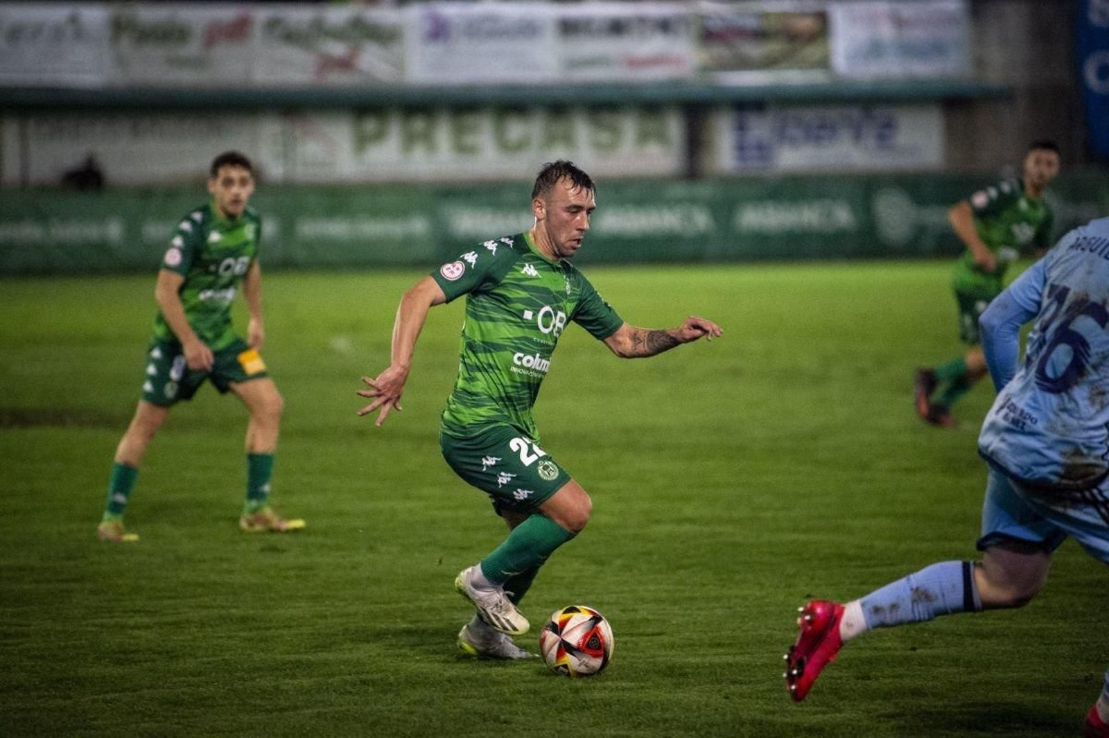 El defensa verde Jordan Sánchez intenta superar a un contrario en un partido en Espiñedo.