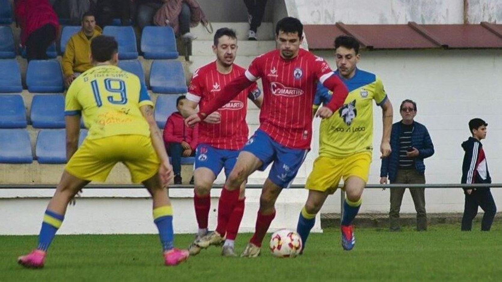 Enio Magro, centrocampista del Verín, conduce el balón ante dos contrarios en el José Arjiz. (Foto: Lucía Otero)