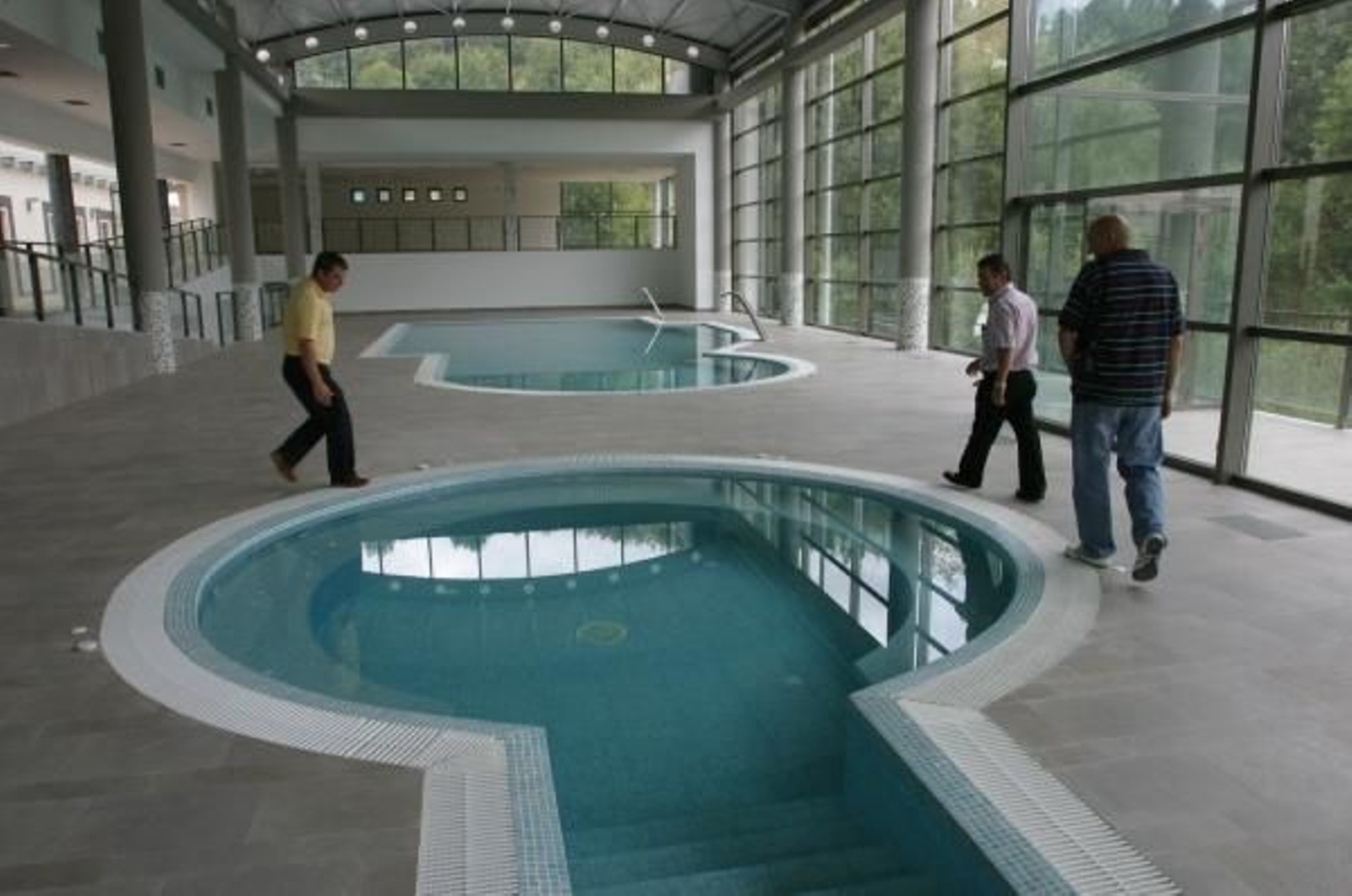 Un grupo de visitantes admira las piscinas del interior del balneario de Berán. (Foto: Xesús Fariñas)