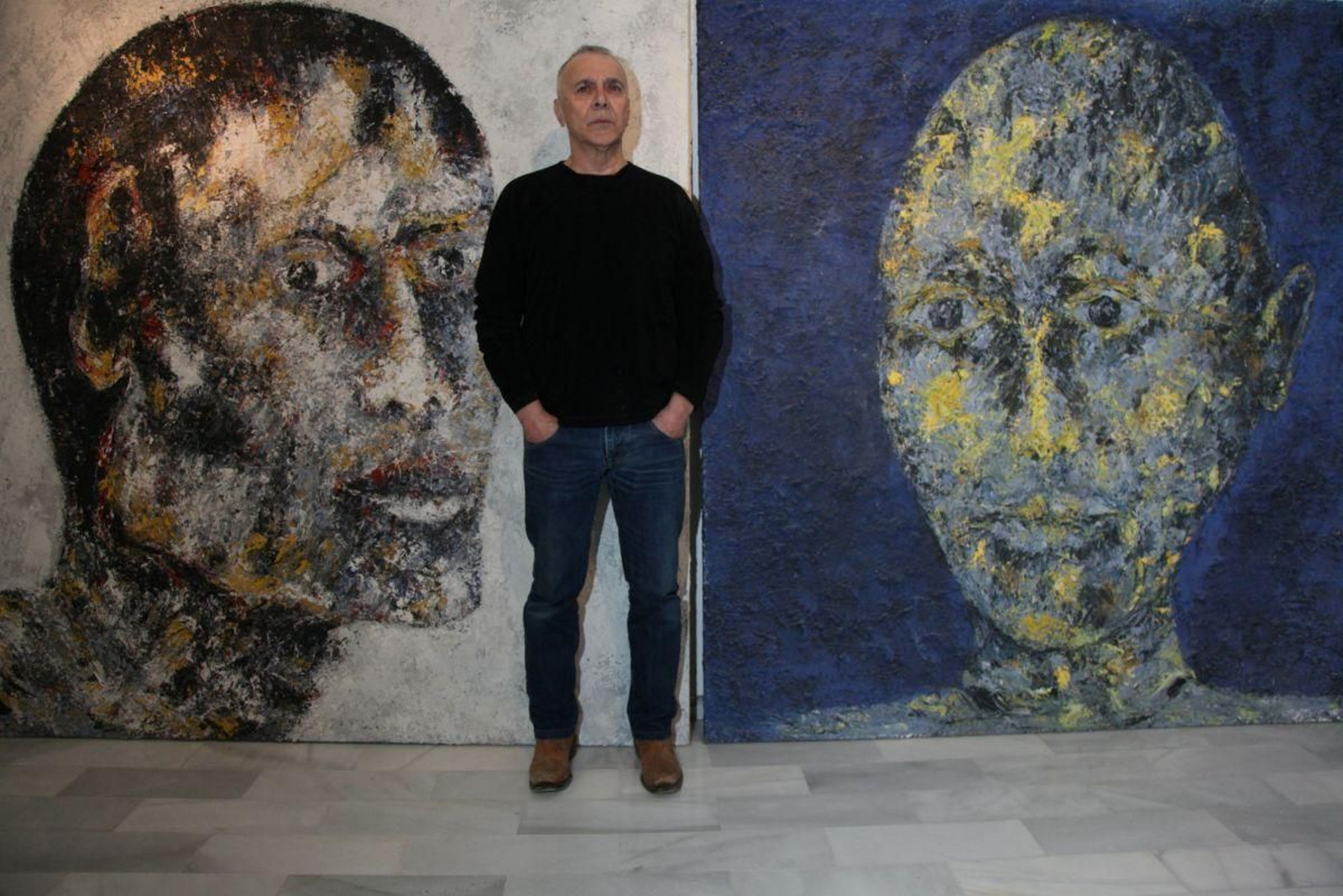 Alexandro posa con dos de sus obras en una exposición en el centro cultural Marcos Valcárcel.