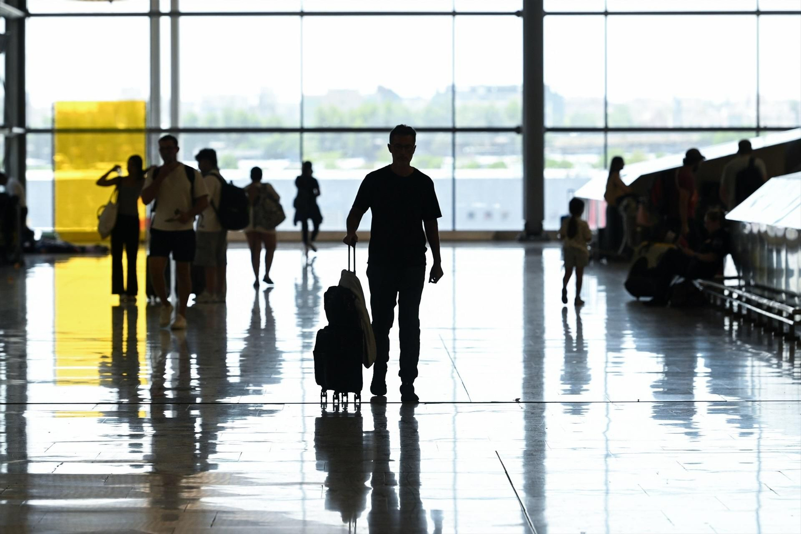 Varios viajeros en la zona de llegadas, en la T4,