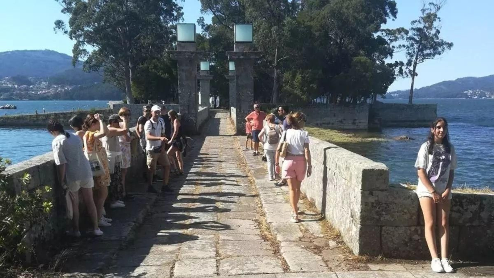 Un grupo de visitantes en el puente que une la isla de San Simón y San Antón.