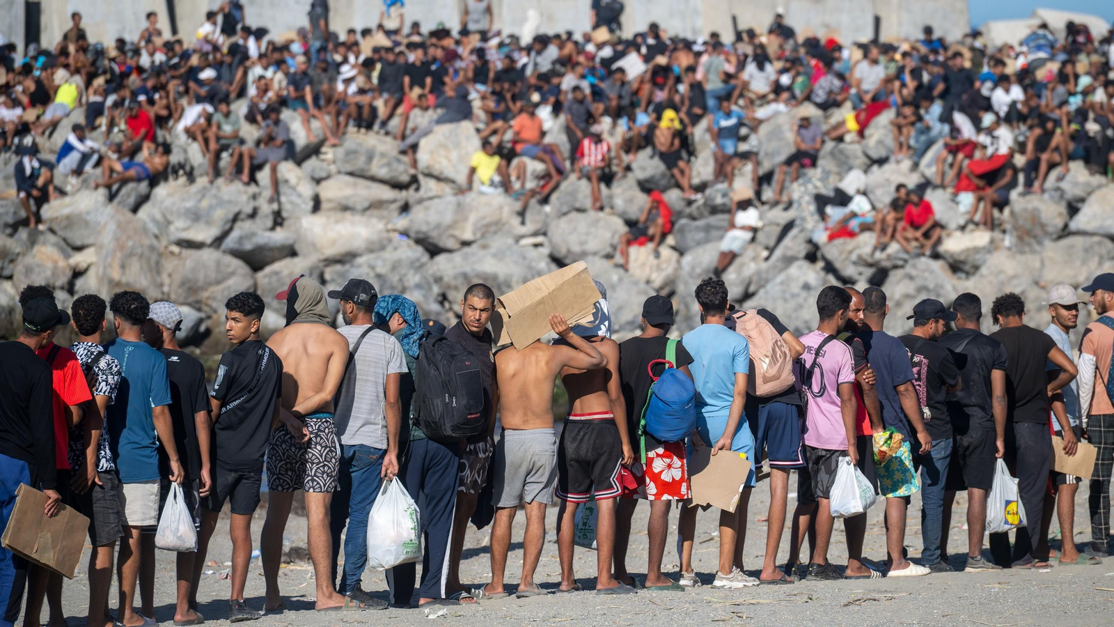 Varios inmigrantes en una playa, a 21 de agosto de 2026, en Ceuta (España).