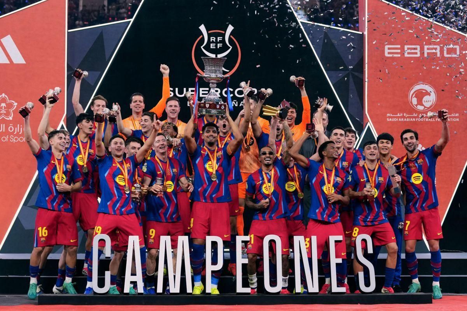 Los jugadores del Fútbol Club Barcelona levantan el trofeo que les acredita como campeones de la Supercopa de España tras vencer al Real Madrid.