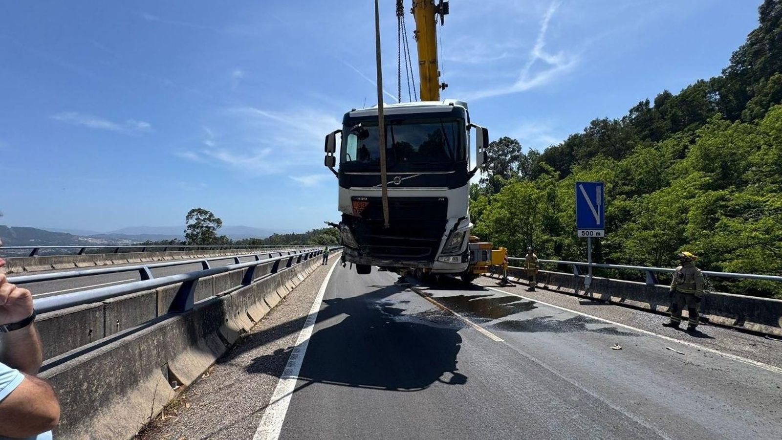 Retirada del camión accidentado en la AP-9 con una grúa.