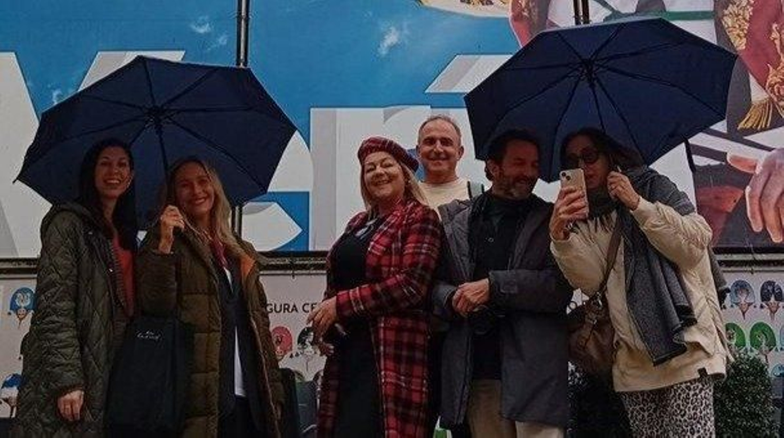 Los influencers posan junto al mural del cigarrón durante su recorrido por Verín.