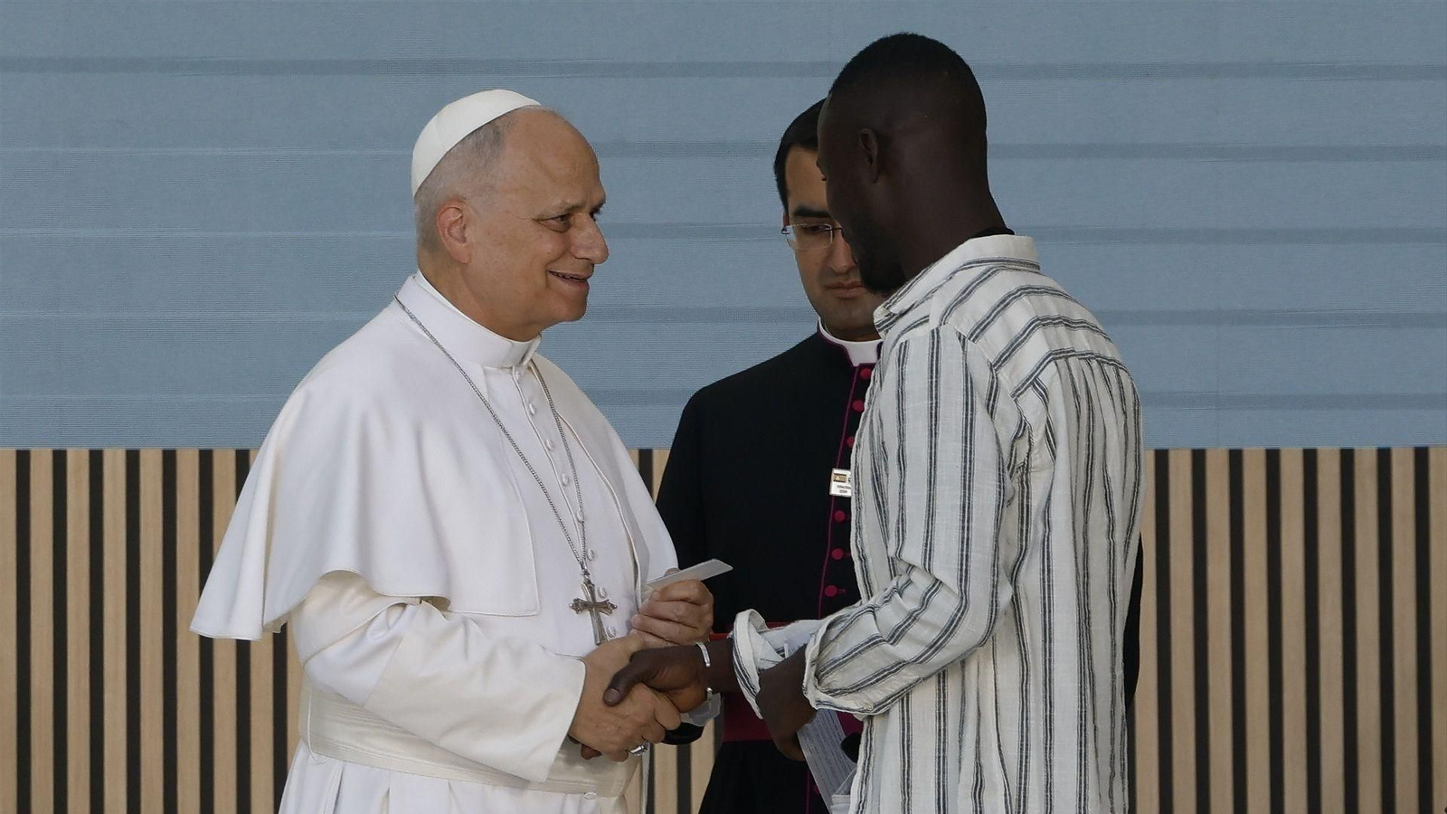 El papa León XIV recibe la réplica de la tarjeta de residencia de Kendry, uno de los inmigrantes beneficados por Cáritas.