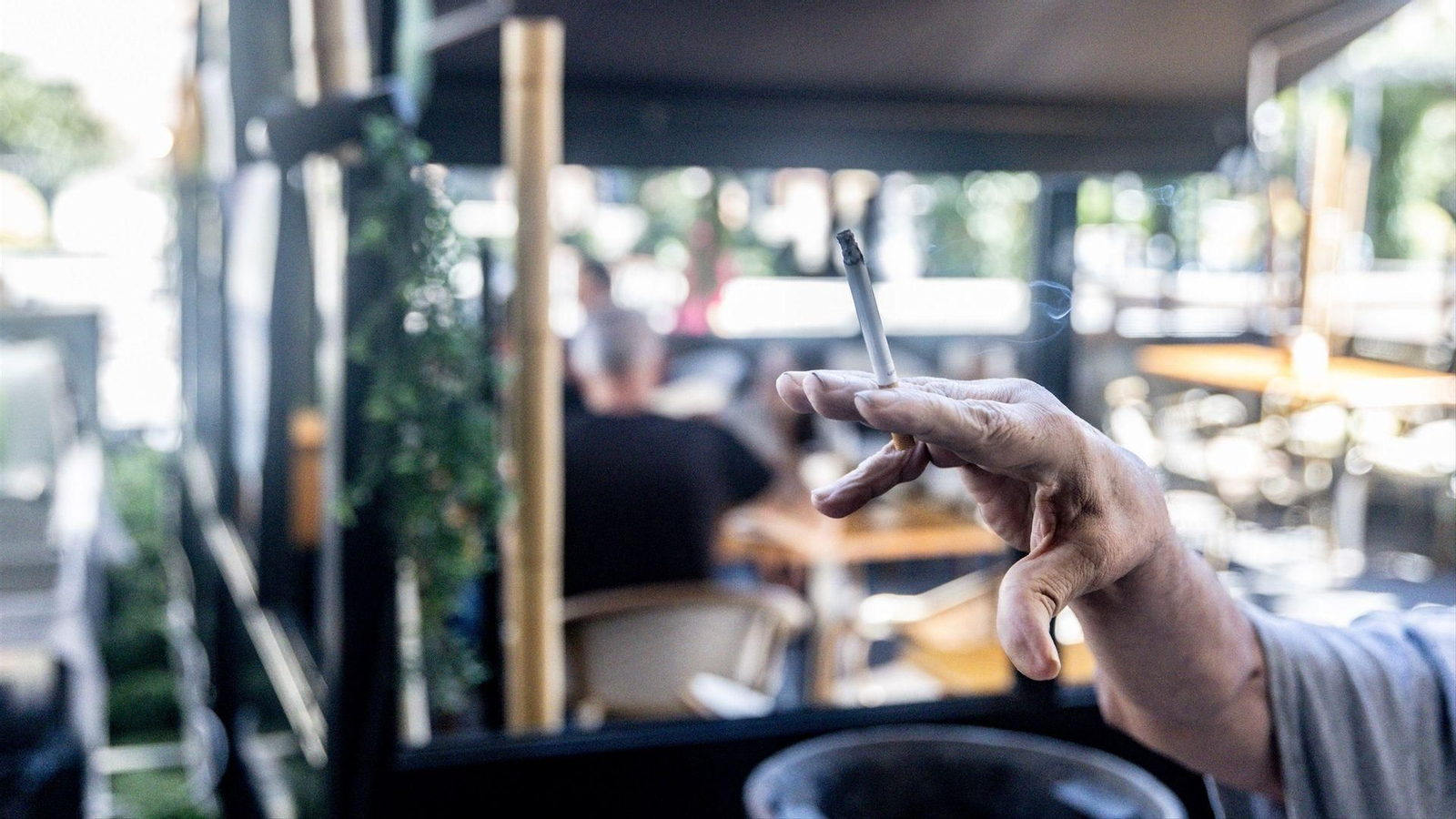 Una persona fuma en una terraza, en una imagen de archivo, algo que estará prohibido con la nueva ley del tabaco.