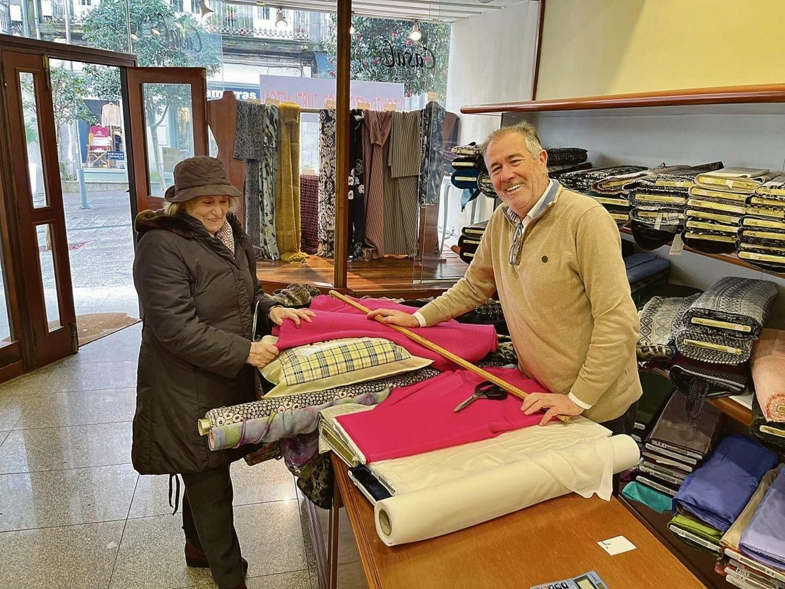 José Ángel Casal se jubila y echará el cierre a uno de los comercios más tradicionales del centro de Vigo. En la foto con su clienta Mindocha.