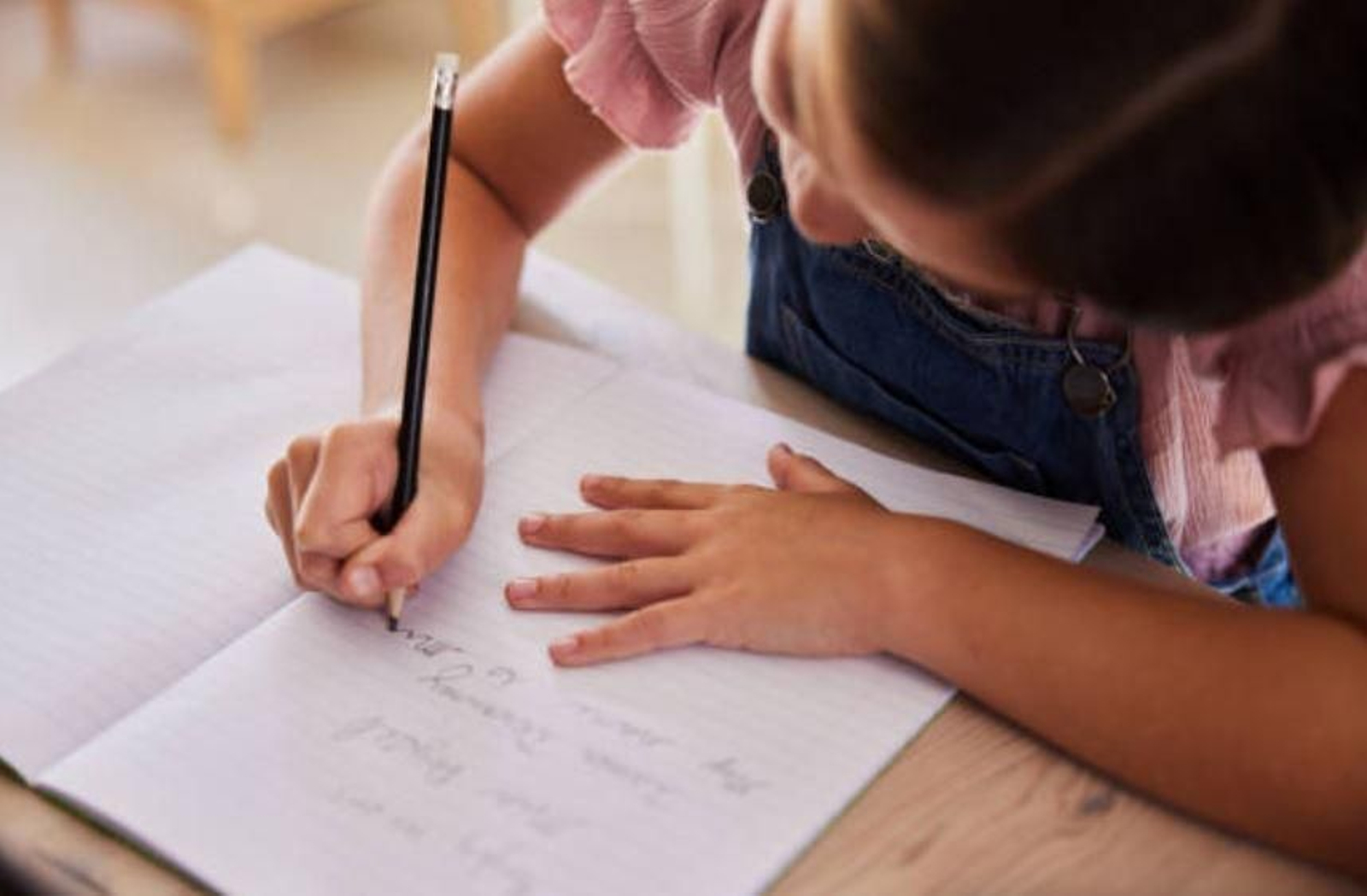 Una niña escribiendo en la escuela.