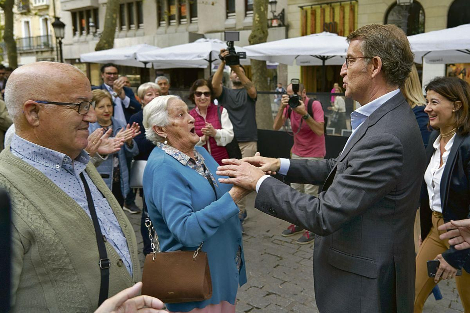 Núñez Feijóo saluda a un grupo de vecinos de Vitoria, durante un paseo por la capital vasca.