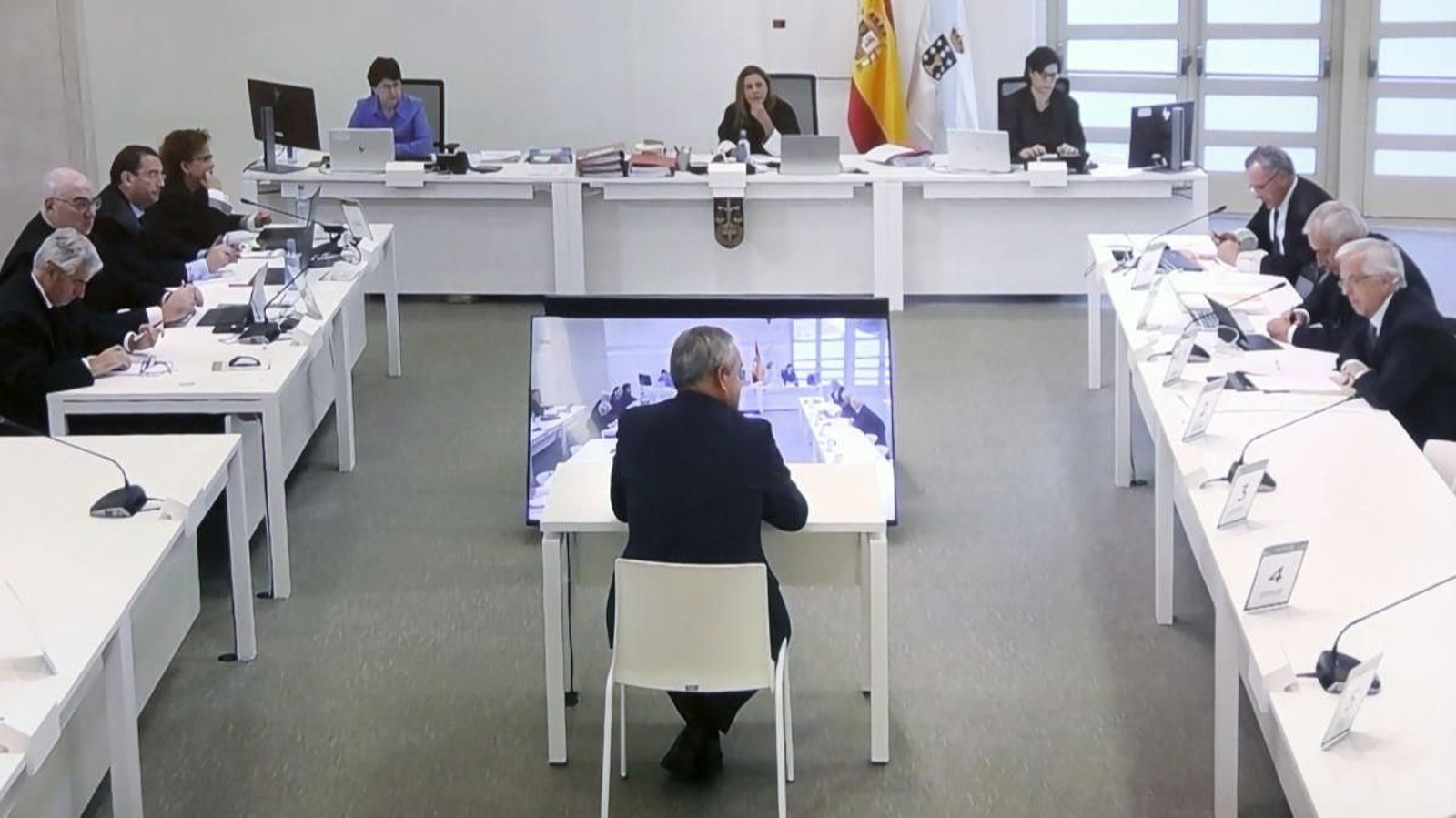 Vista de las pantallas que siguen del juicio el caso Alvia. En el centro, a uno de los testigos.