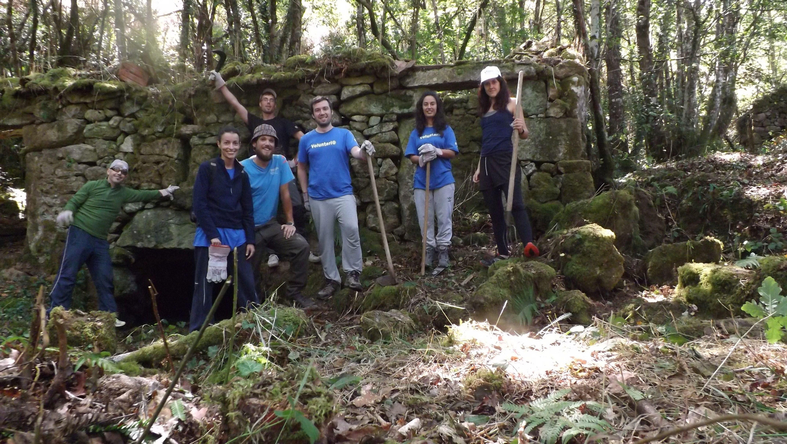 Los voluntarios durante, la jornada de limpieza en el arrollo de Torrente, en Muíños.