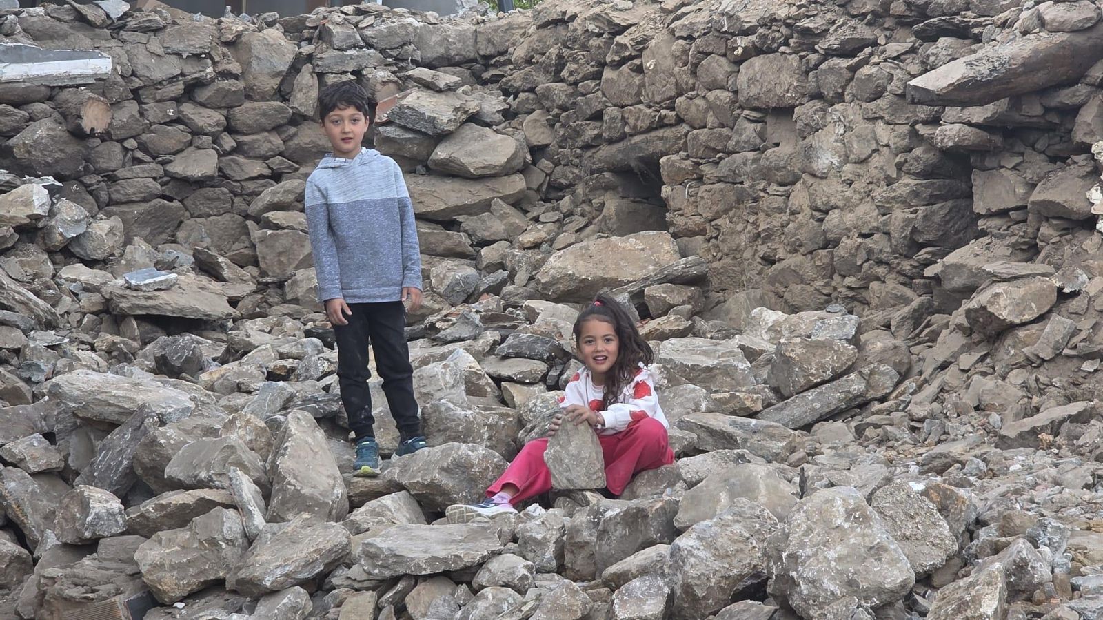 Los hijos de José y Linda Lola juegan en los escombros de su casa .