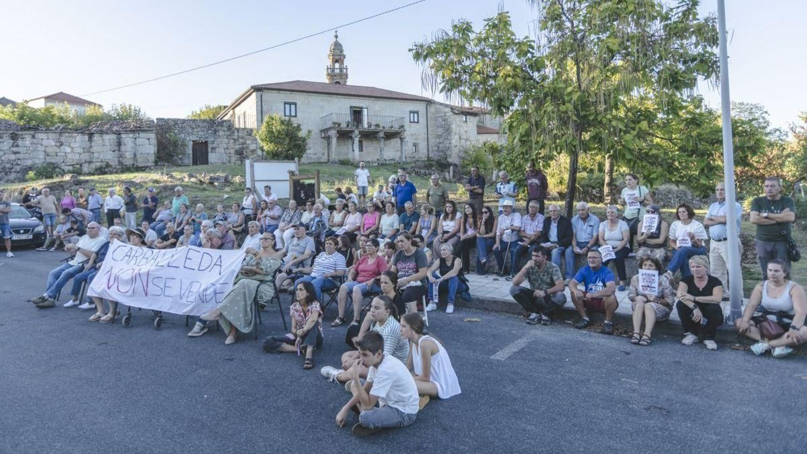Vecinos de Carballeda de Avia, sentados ante el Concello.