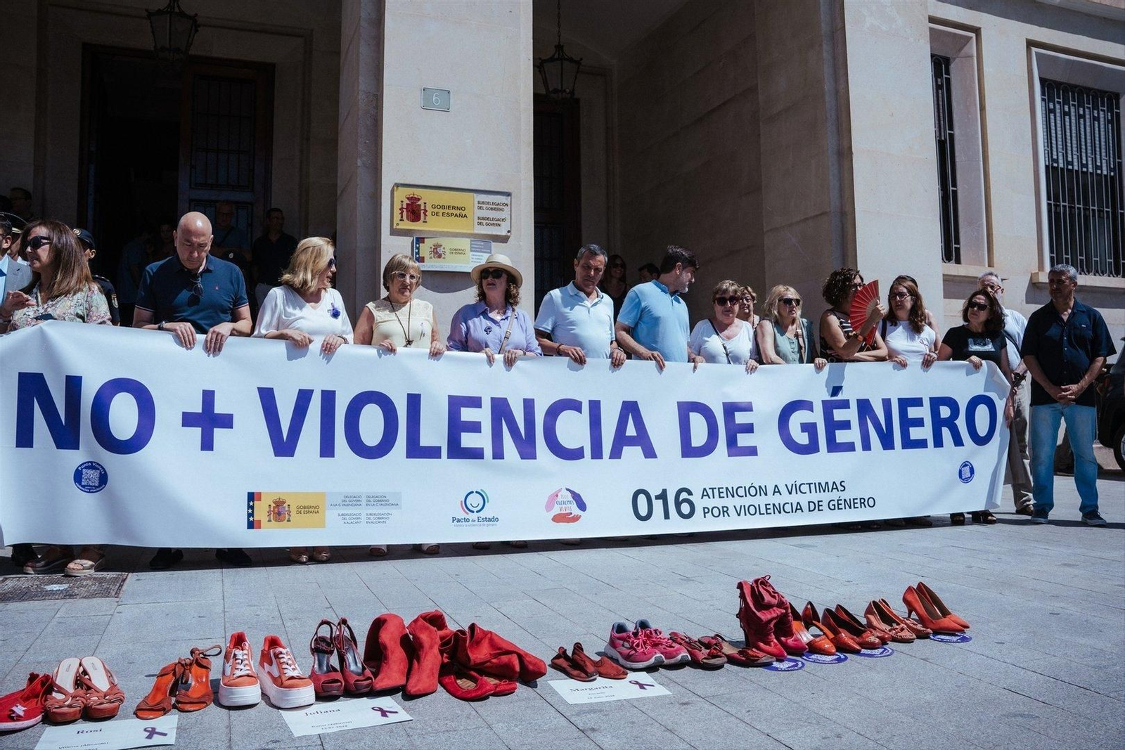 Varios pares de zapatos de color rojo durante un minuto de silencio por la mujer fallecida en Alicante. // E.P.