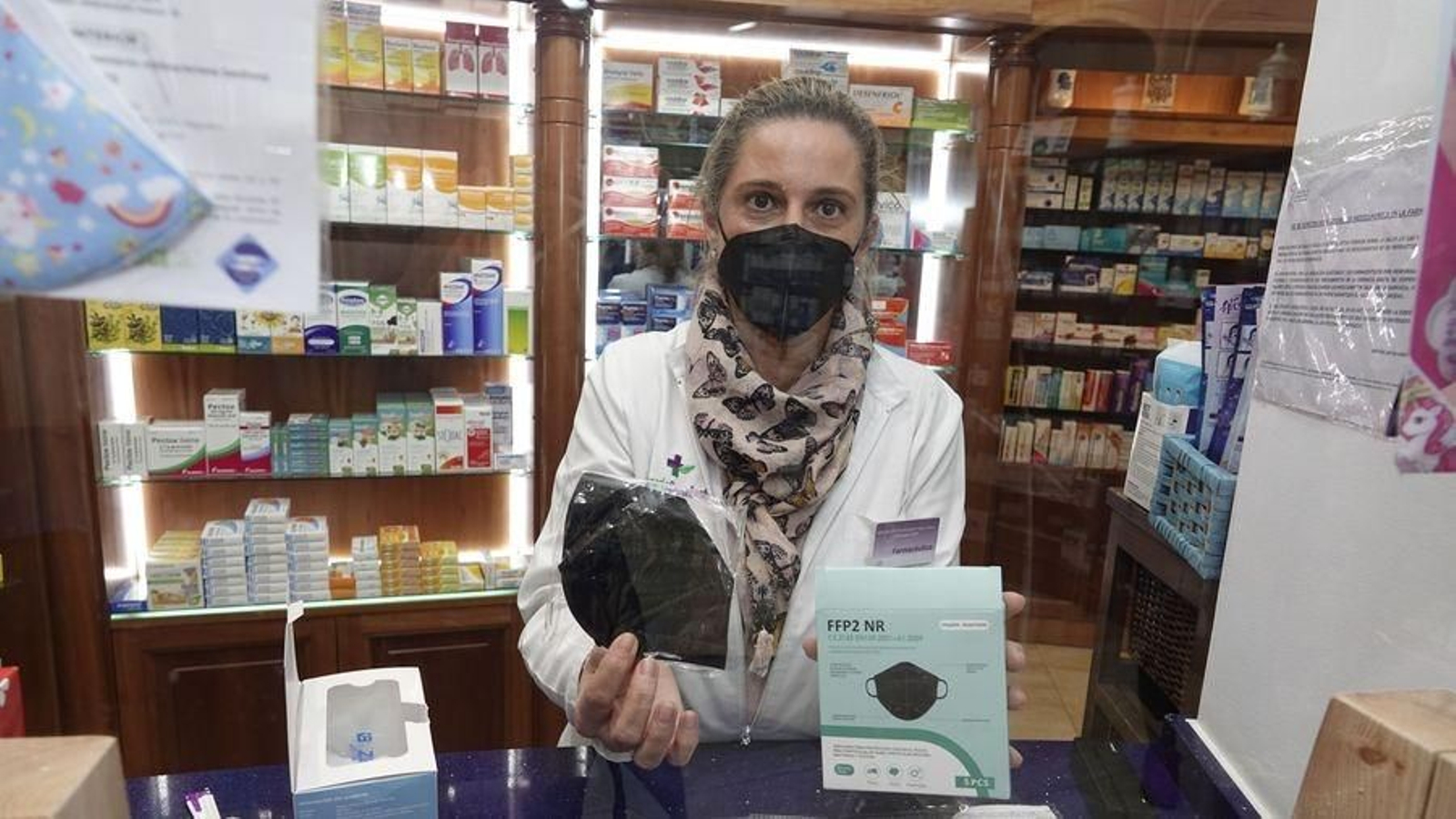 La farmacéutica muestra los diferentes modelos de mascarillas FFP2 a la venta.