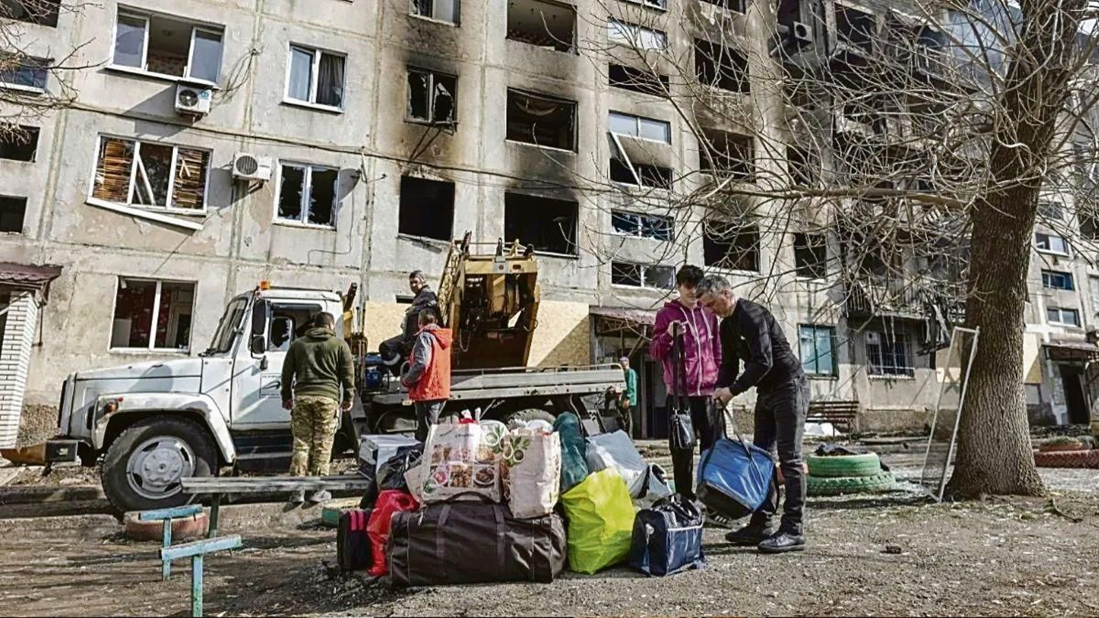 Una familia recoge sus pertenencias de su vivienda destruida por ataques rusos en Donetsk.