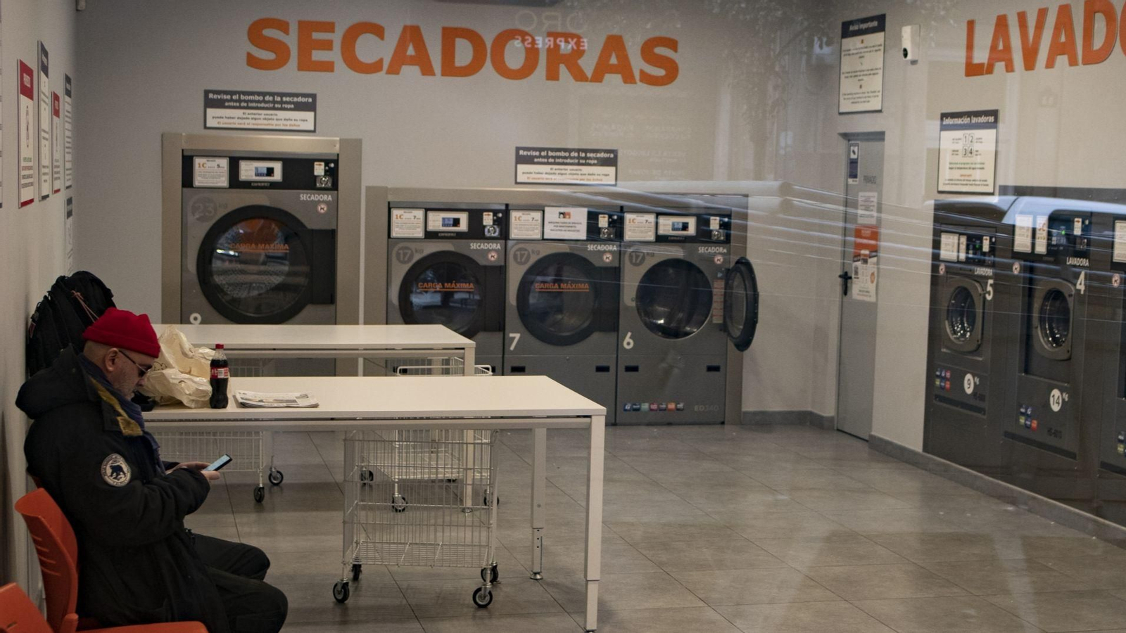 Un ourensano espera por su colada en un establecimiento de autoservicio.