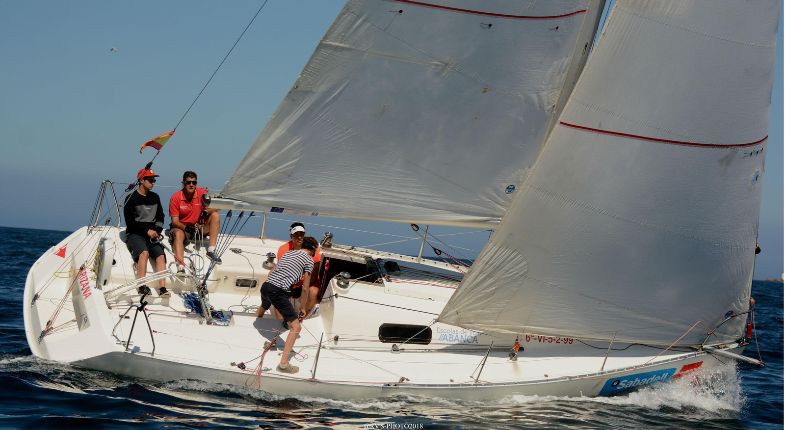 Arriba, el AXA, tripulado por alumnos de la Escuela de Vela Adaptada.