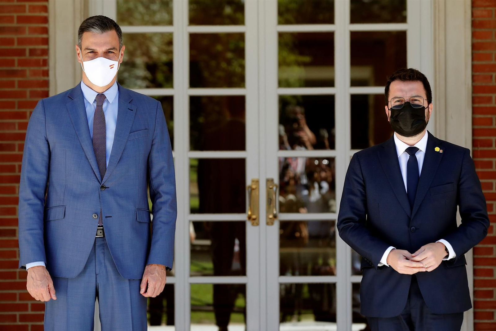 El presidente del Gobierno, Pedro Sánchez, saluda y recibe al presidente de la Generalitat, Pere Aragonès, en la entrada de Moncloa. // EFE